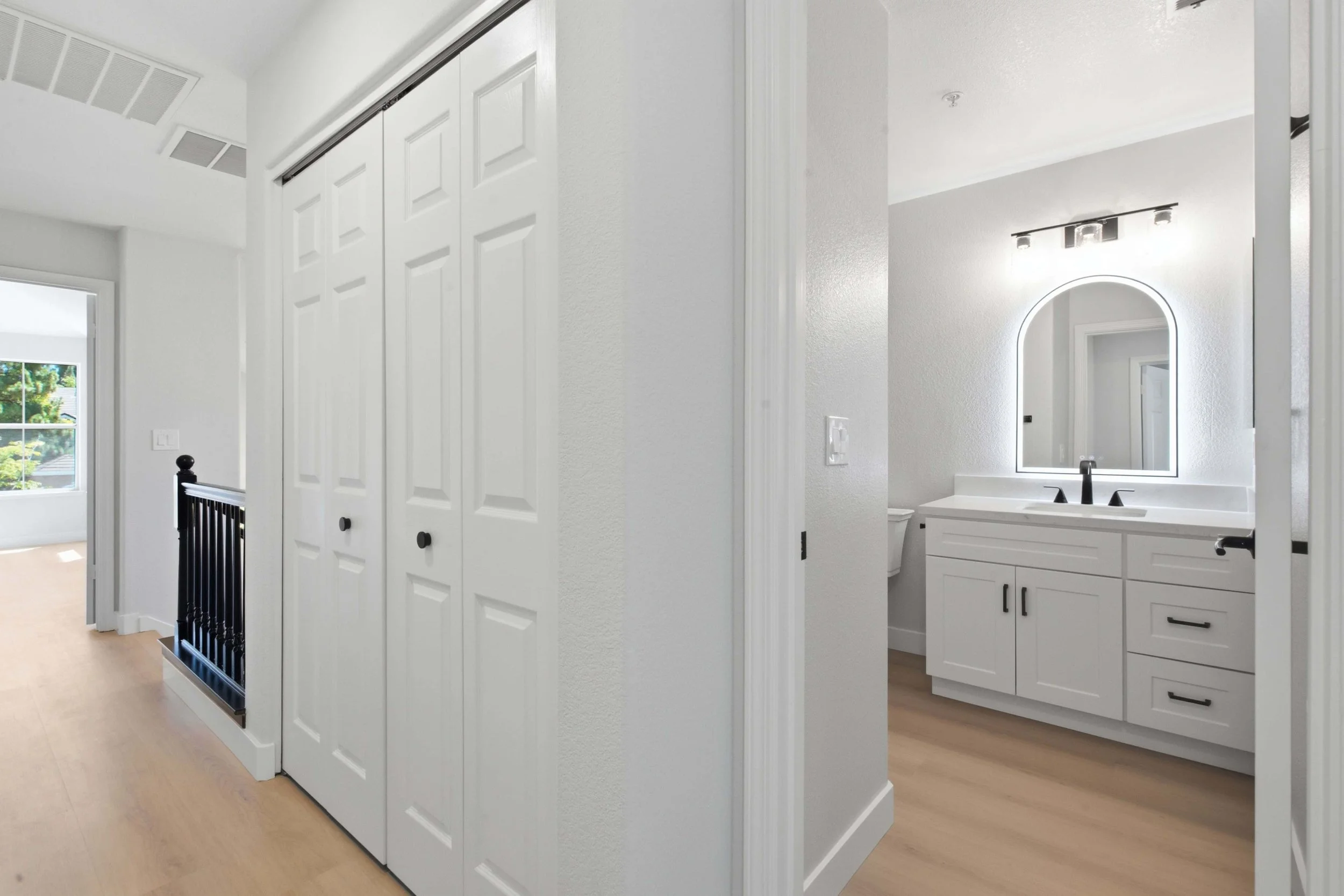 San Jose area renovated condo. This photo has a view from a hallway into the bathroom and on the left side a bedroom's window.