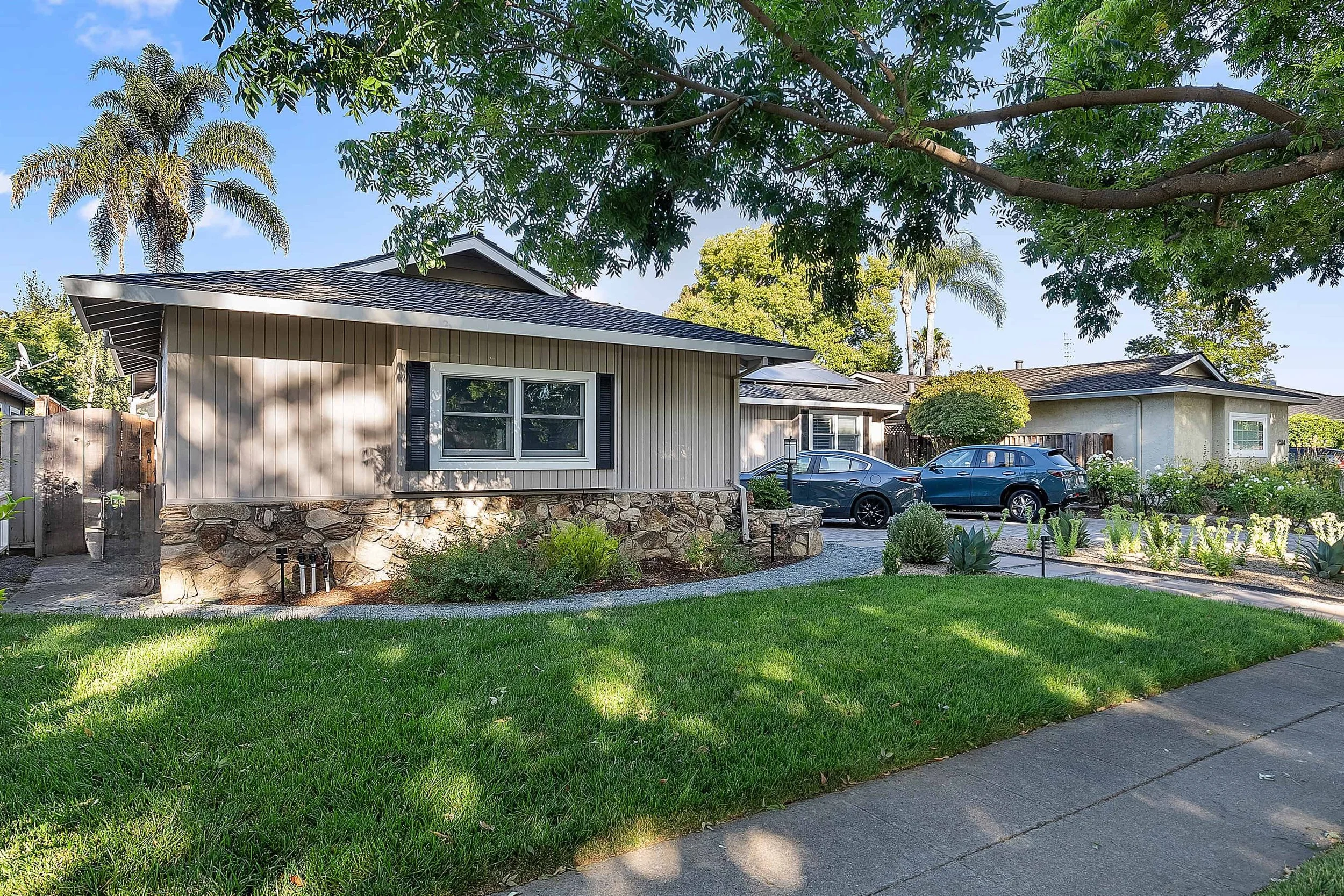 Street view of house with newly restored horizontal wood trim in beige.