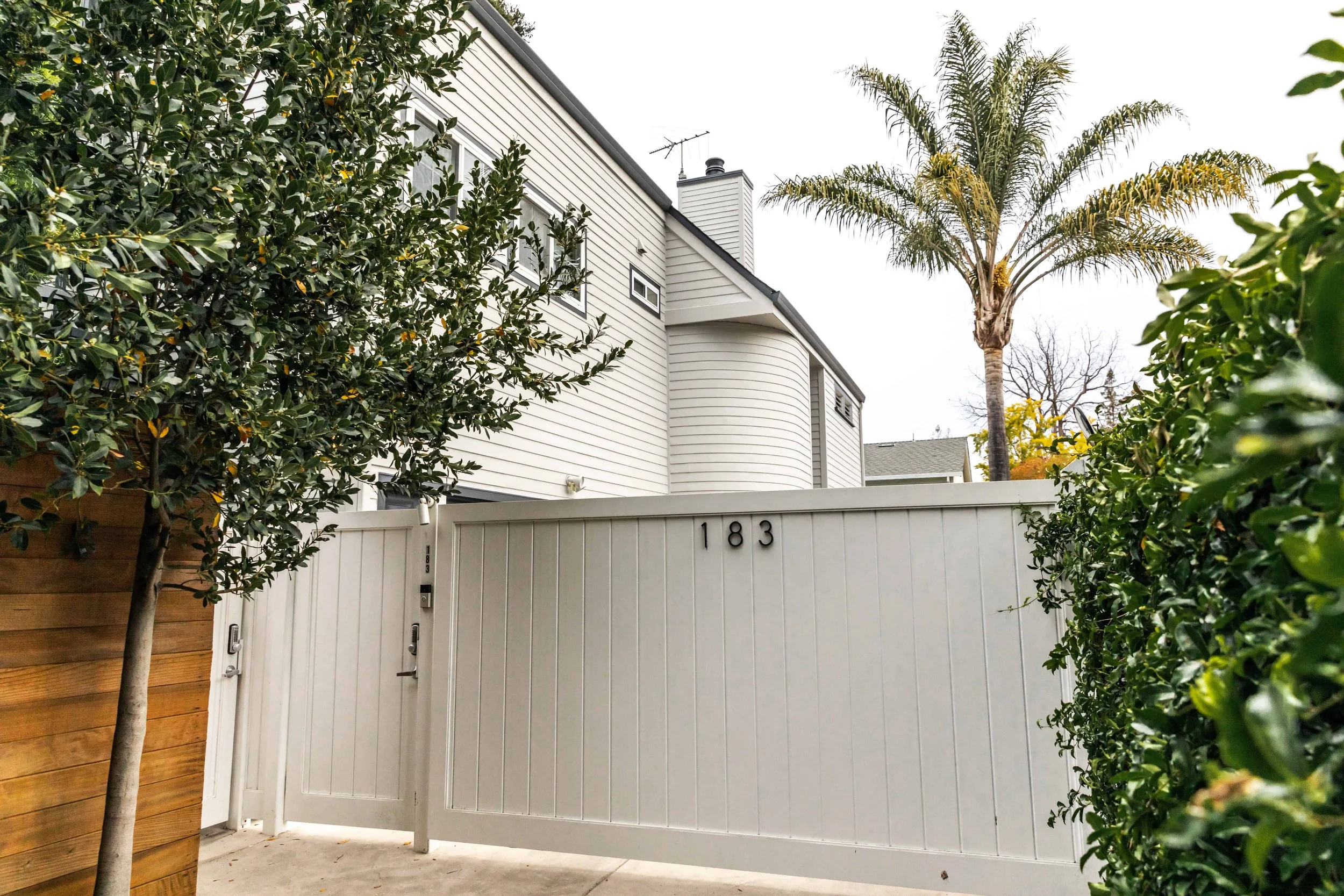 Backyard of a house in Silicon Valley with white gate.