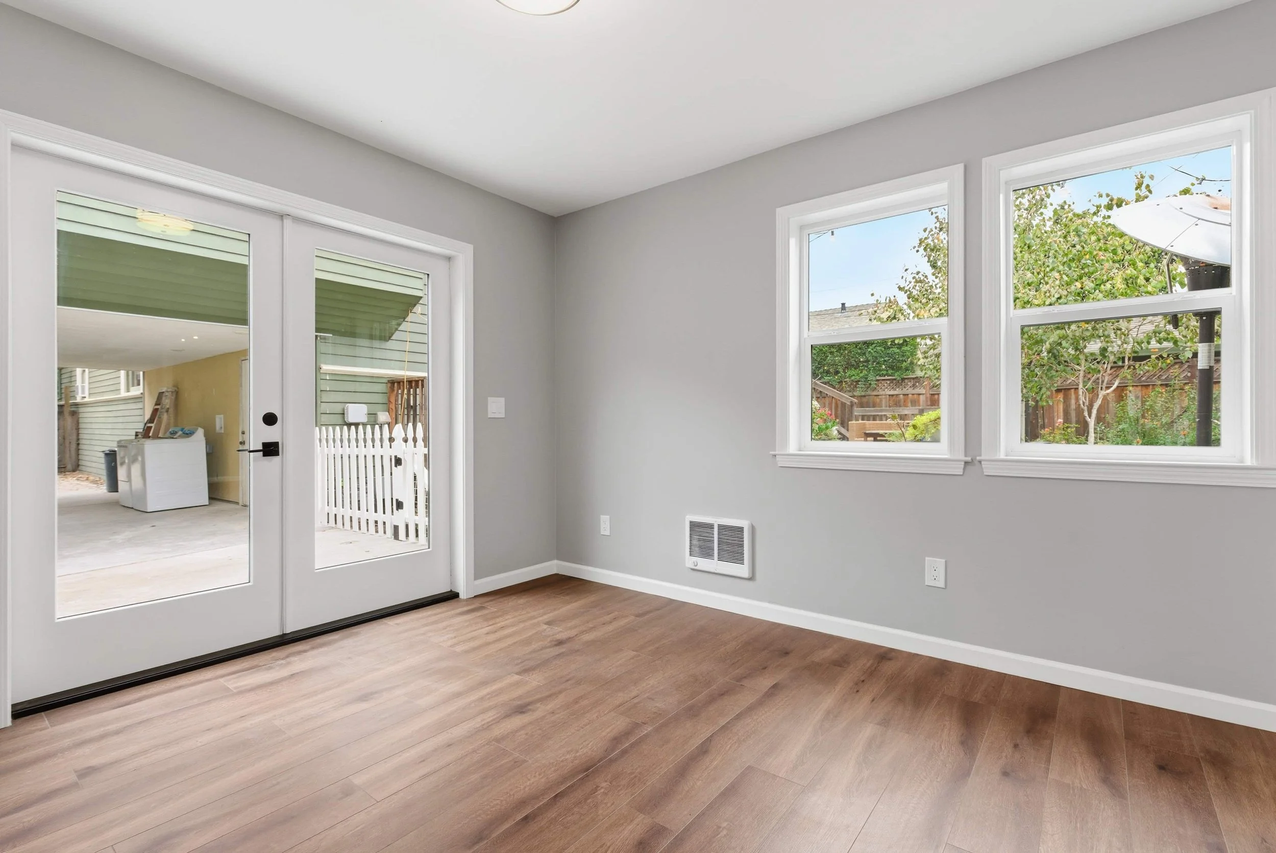 Interior of Naglee Park ADU with two French doors, hardwood floors, and gray walls.