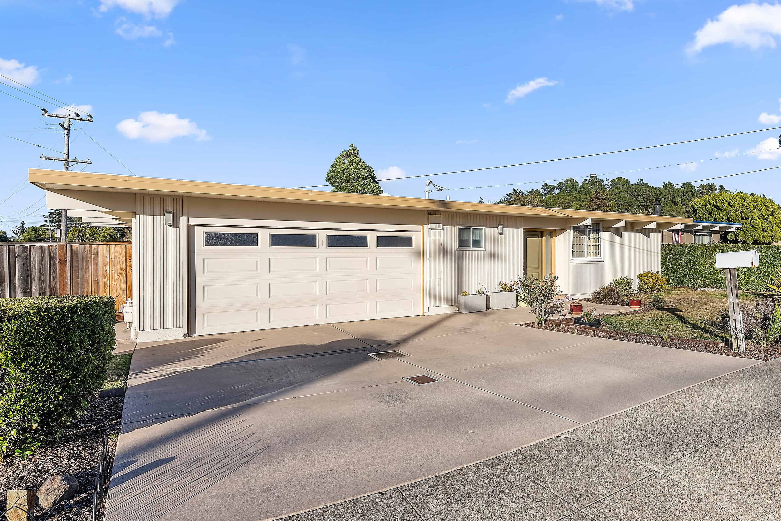 A white newly board and batten resided mid-century modern house in San Jose.