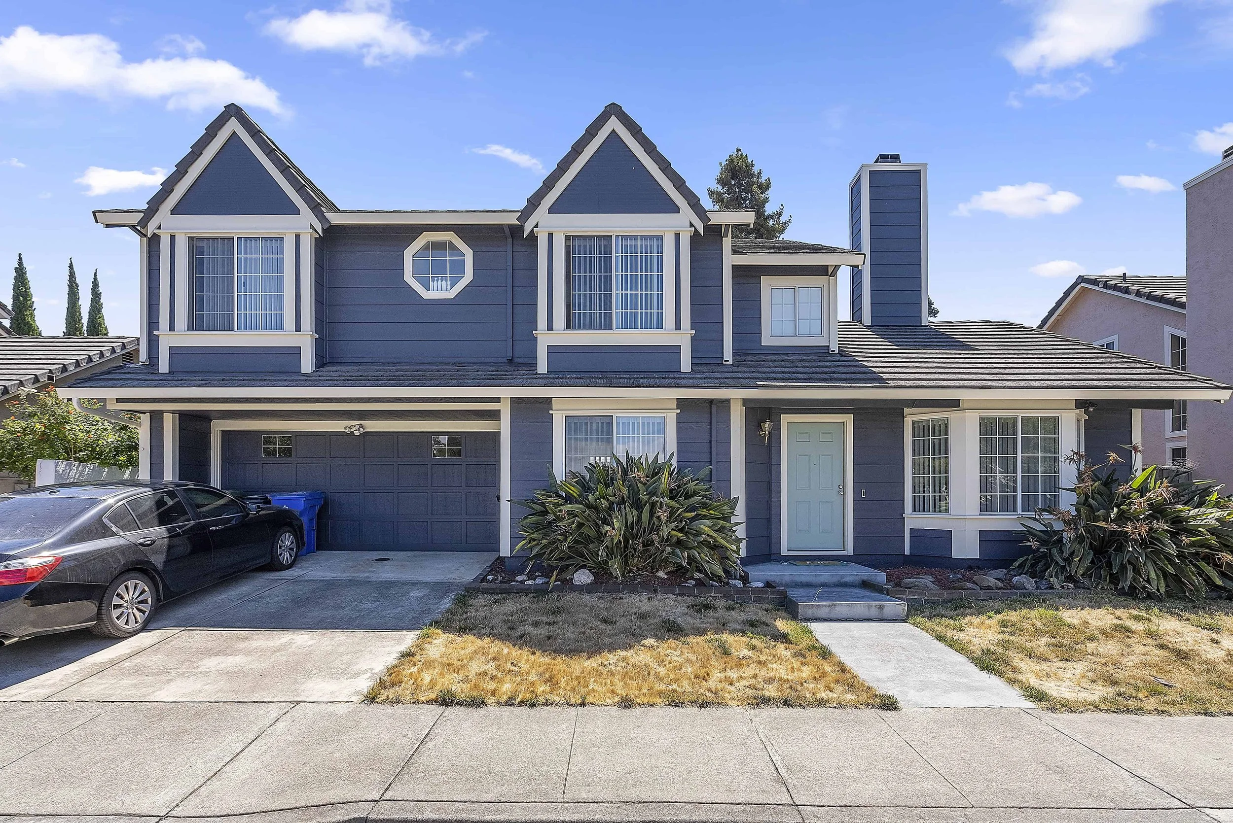 Newly painted blue two story home in San Jose with white trim and light blue front door,