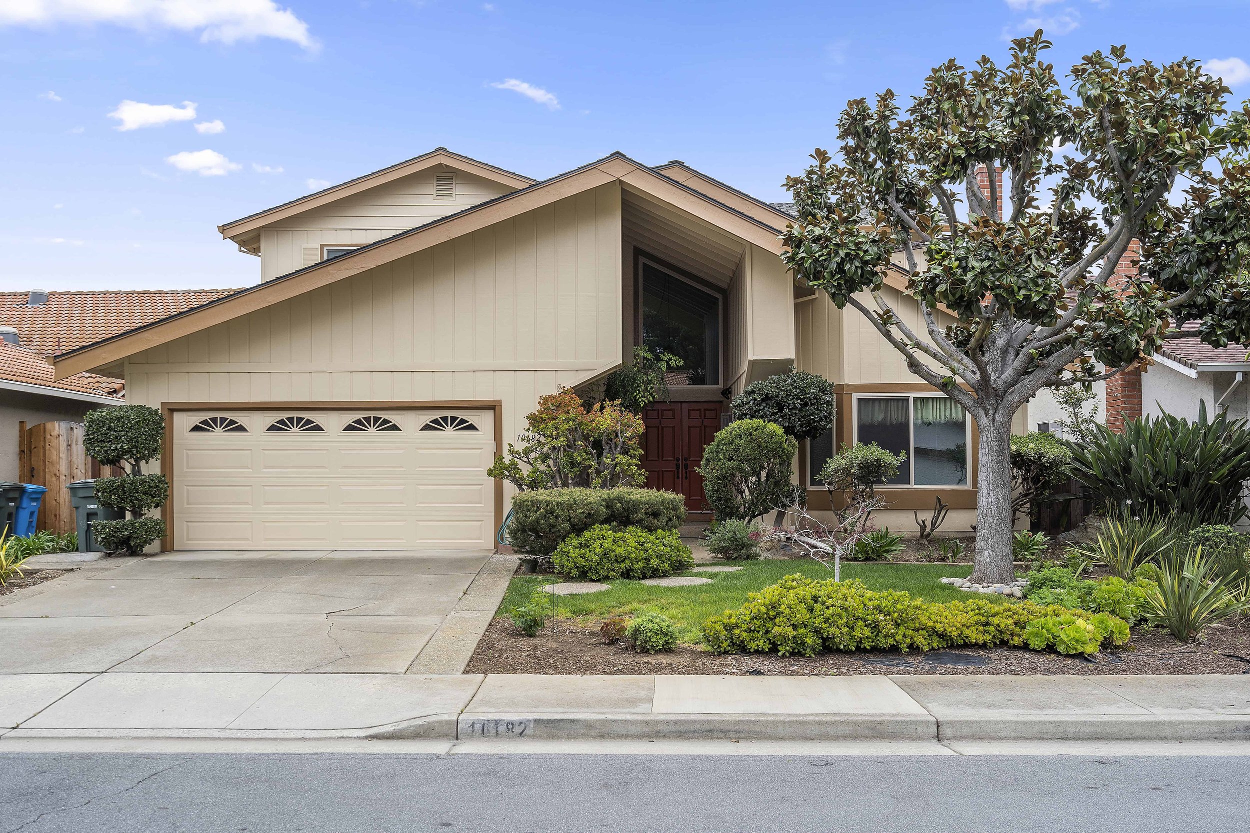 Suburban South Bay house with new bead and batten siding painted in beige with a darker shade of the same color trim.