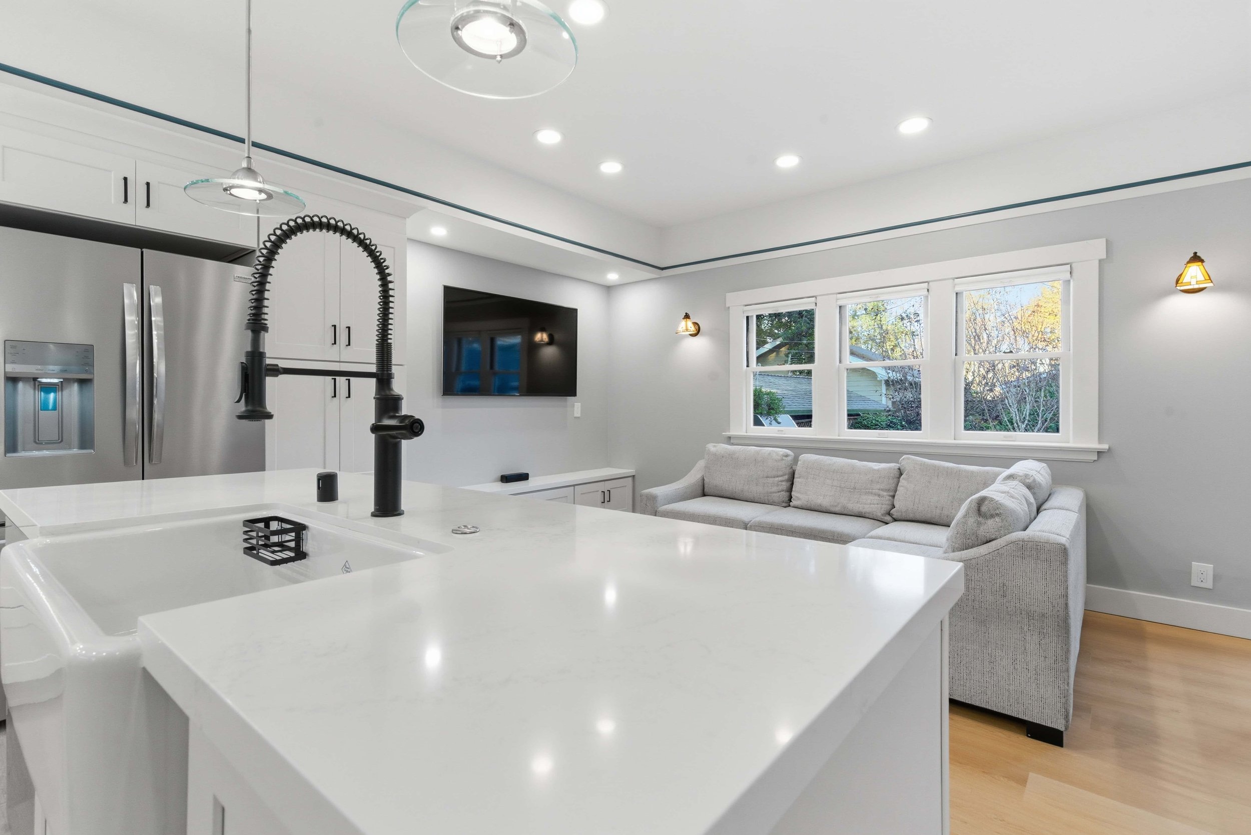 Close up of marble countertops and sink with a matte black commercial style faucet. 