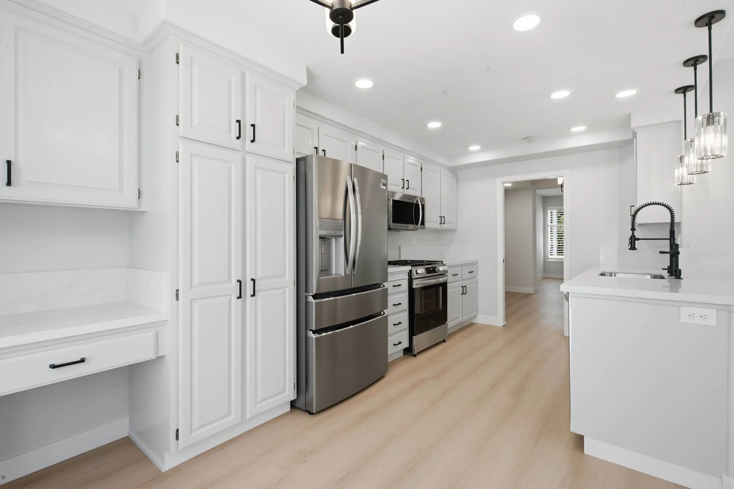 Kitchen in a newly renovated Bay Area condo with new cabinetry, stainless steel appliances, and white marble countertops.