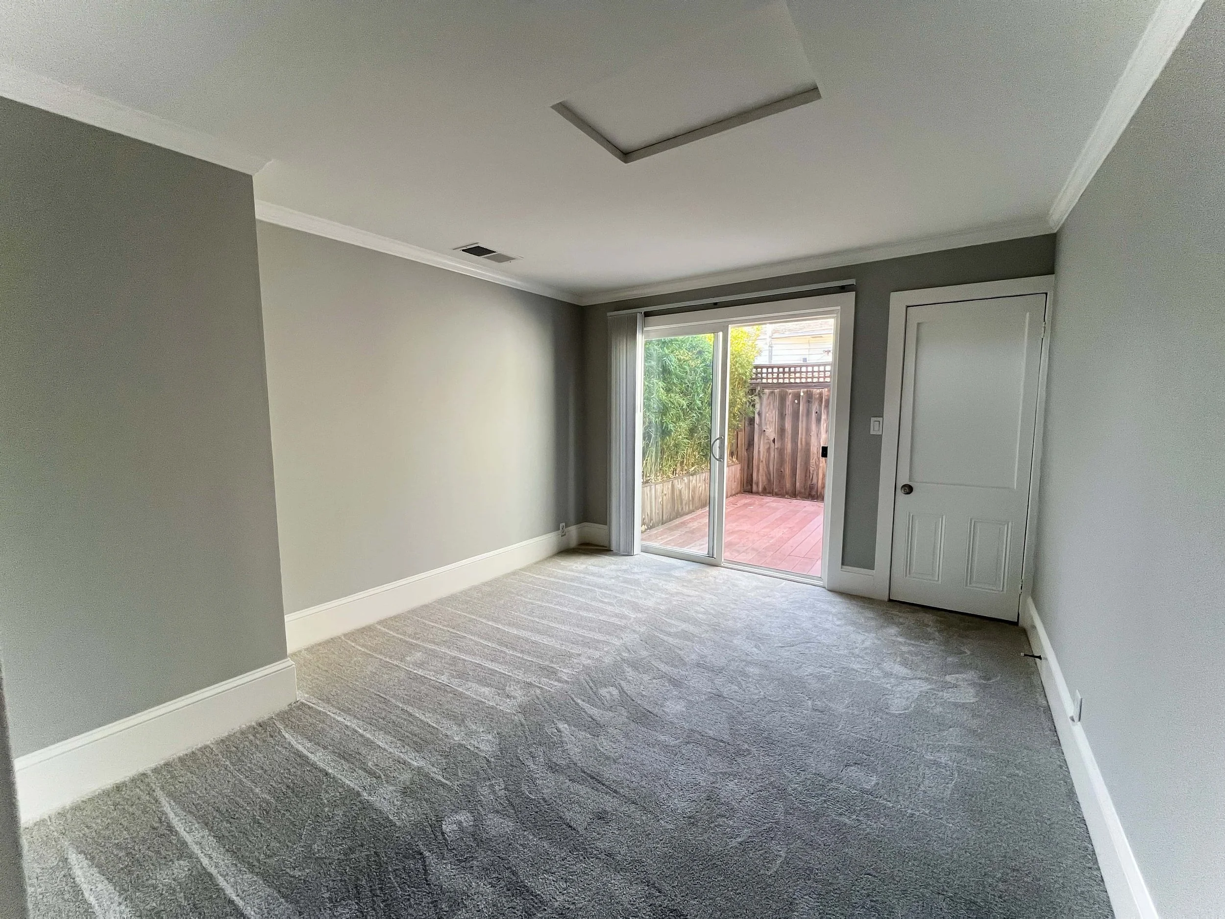 Living room in a downtown San Jose ADU. The room includes a sliding glass door to a bright patio.