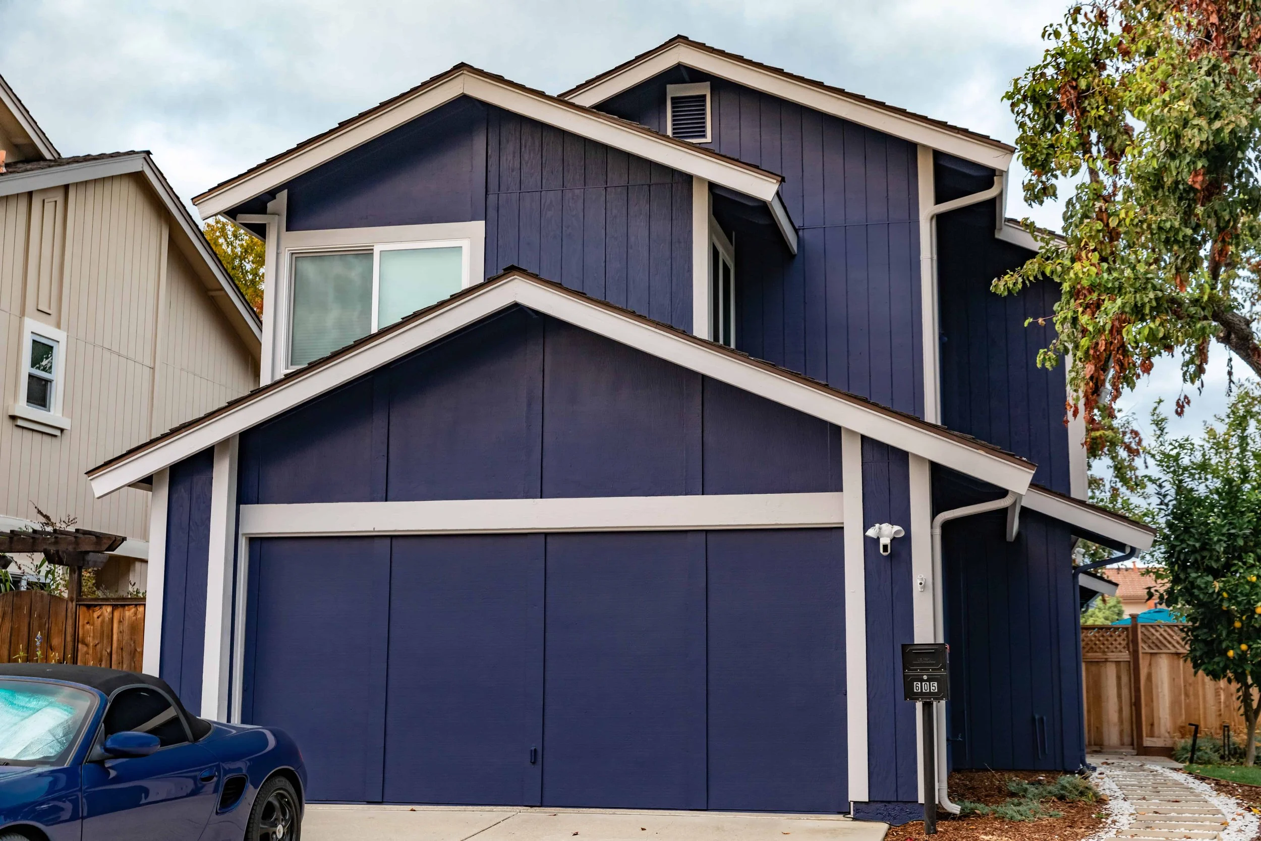 Blue two story house with bead and batten siding and white trim.