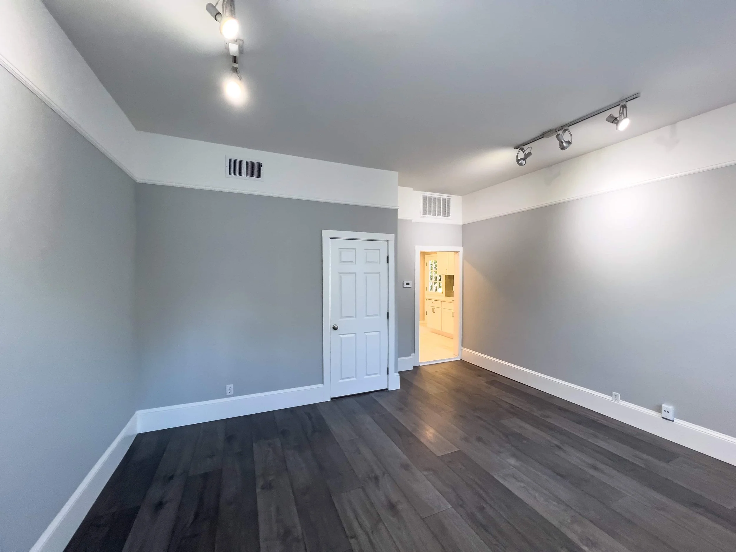 Dark flooring in an ADU. The walls are warm grey with soft lighting.