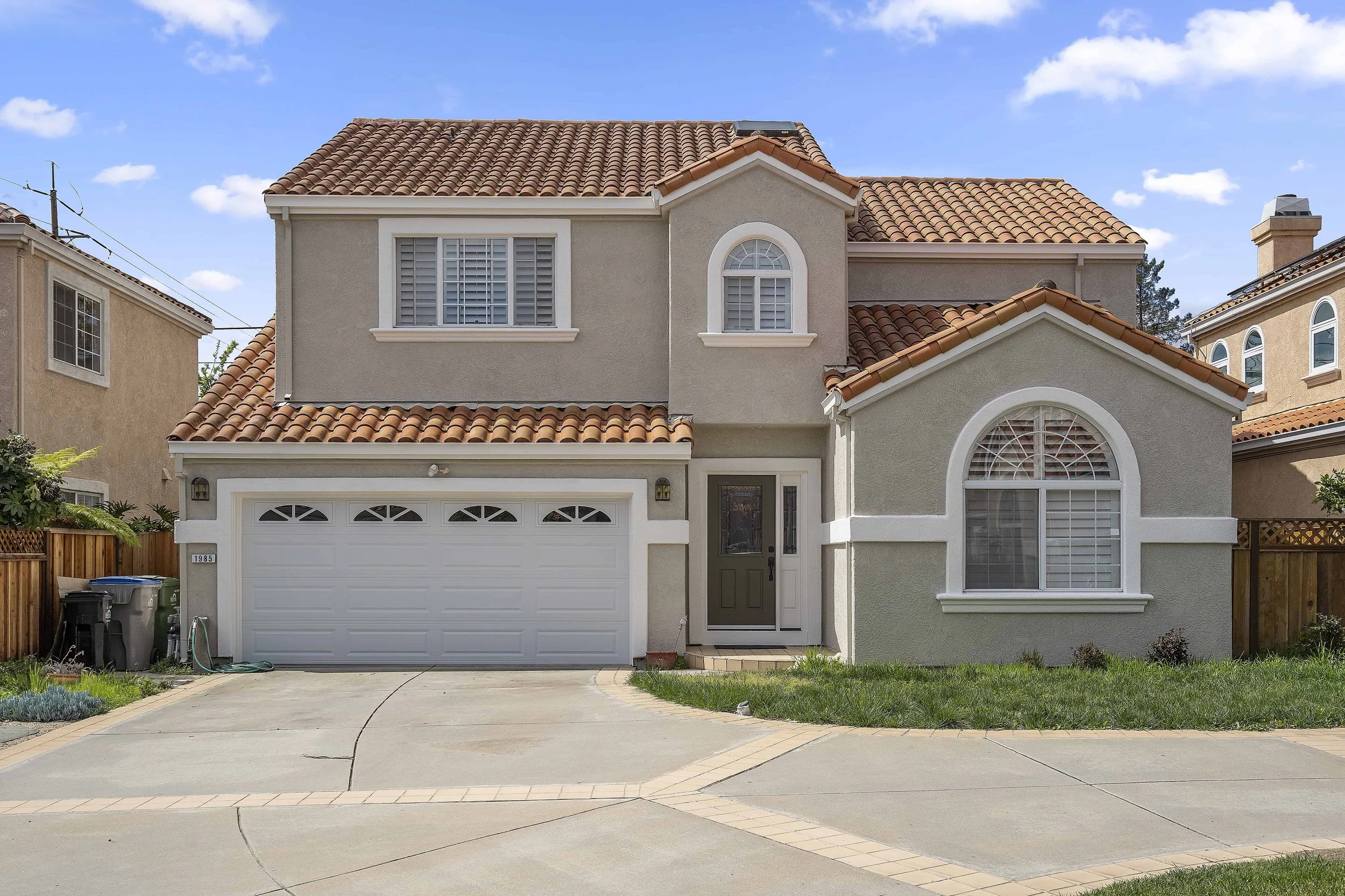 Two story suburban house with beige paint and white trim. 