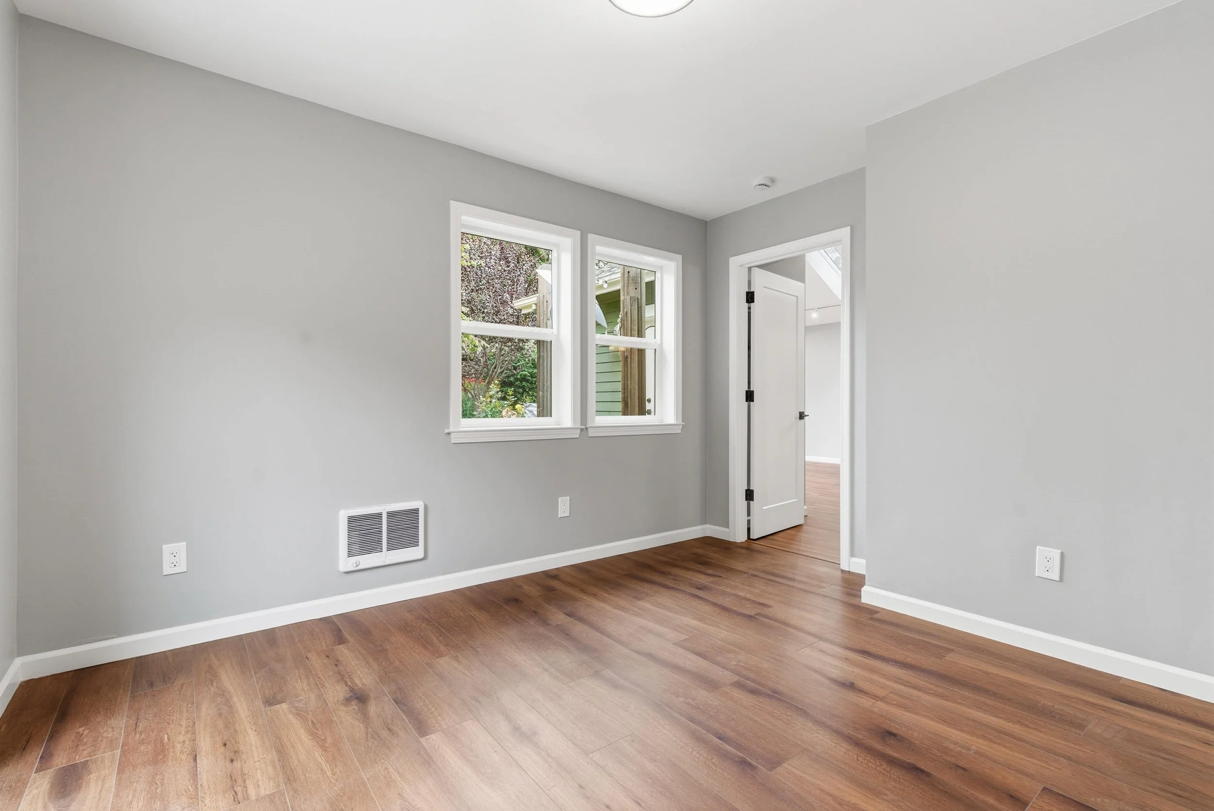 ADU interior living room with gray walls and hardwood floors.