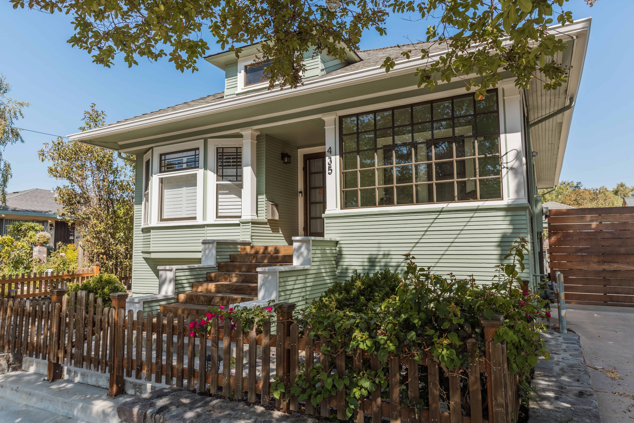 Historic downtown San Jose craftsman home with sage and olive trim new paint and a period appropriate walkway wall leading to the porch.