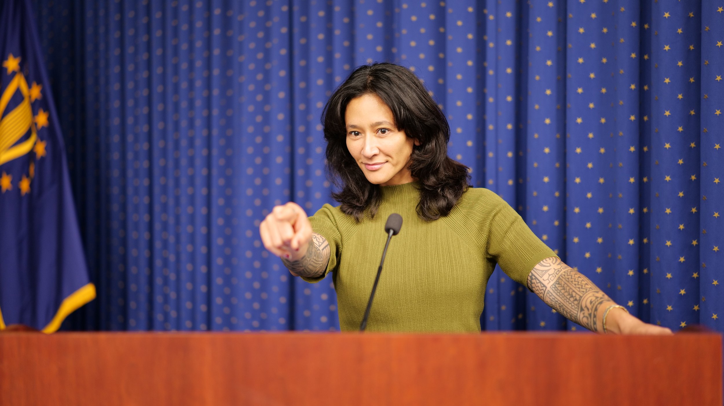 Samantha Juan speaking confidently from a podium during a public event.