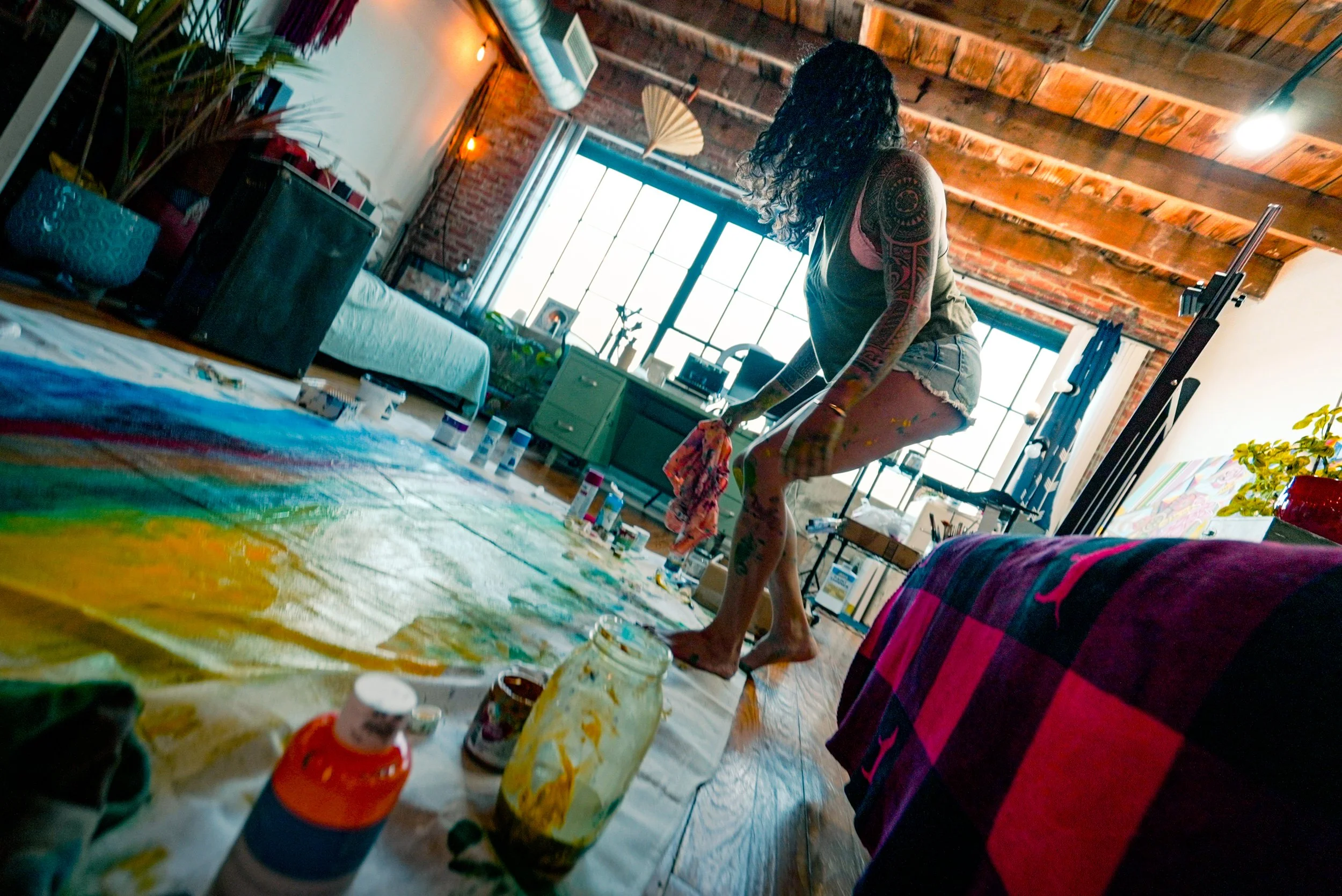 Samantha Juan painting inside a loft-style space during a healing ceremony in Dallas.