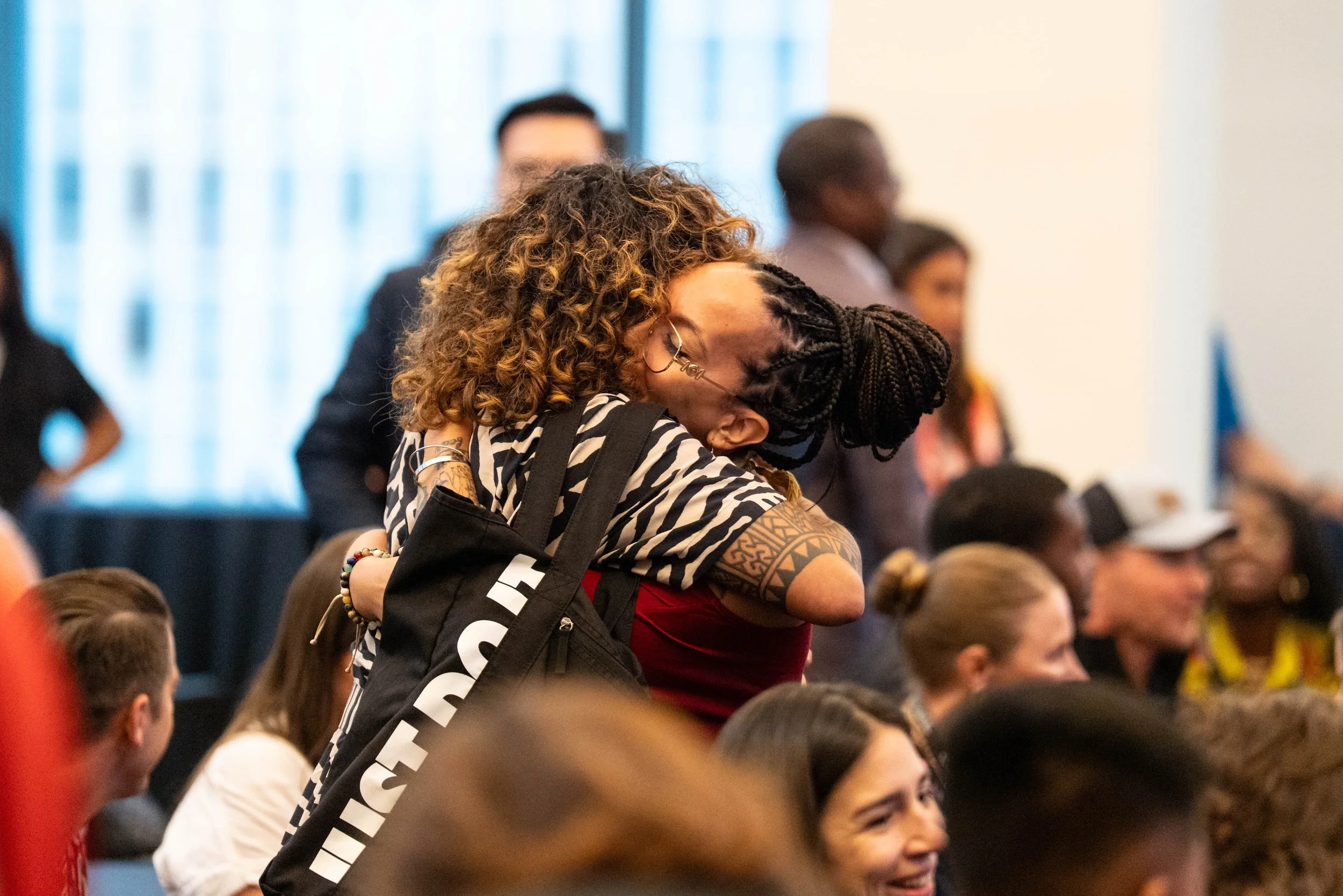 Samantha Juan embracing another attendee during a community gathering at Workhouse Arts Center.