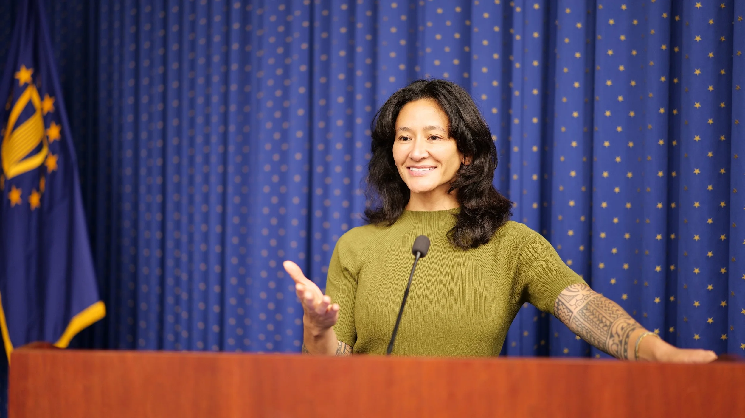 Samantha Juan delivering a speech from a podium during a public event.