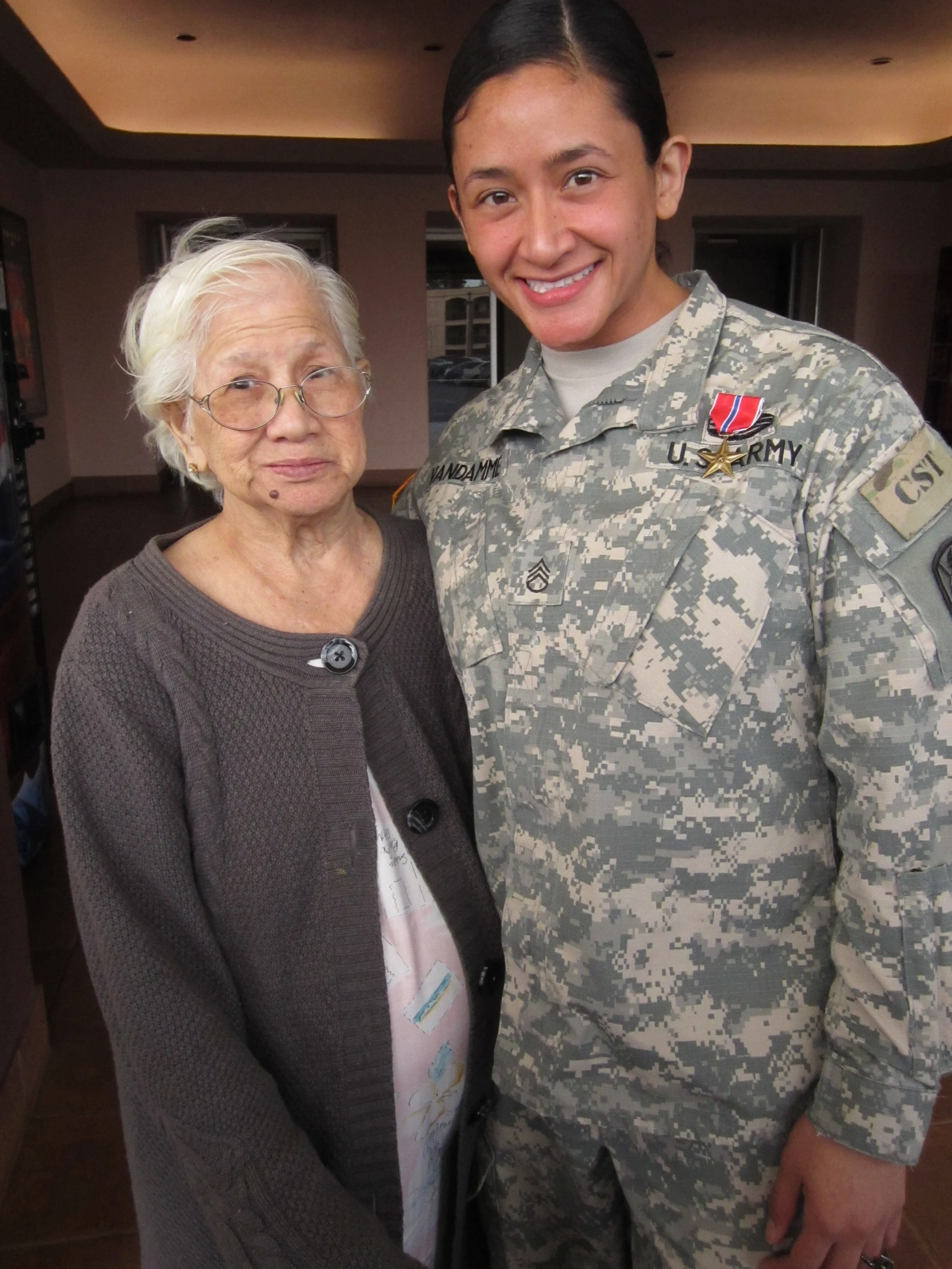 Samantha Juan in her U.S. Army uniform posing with an instructor at art school.