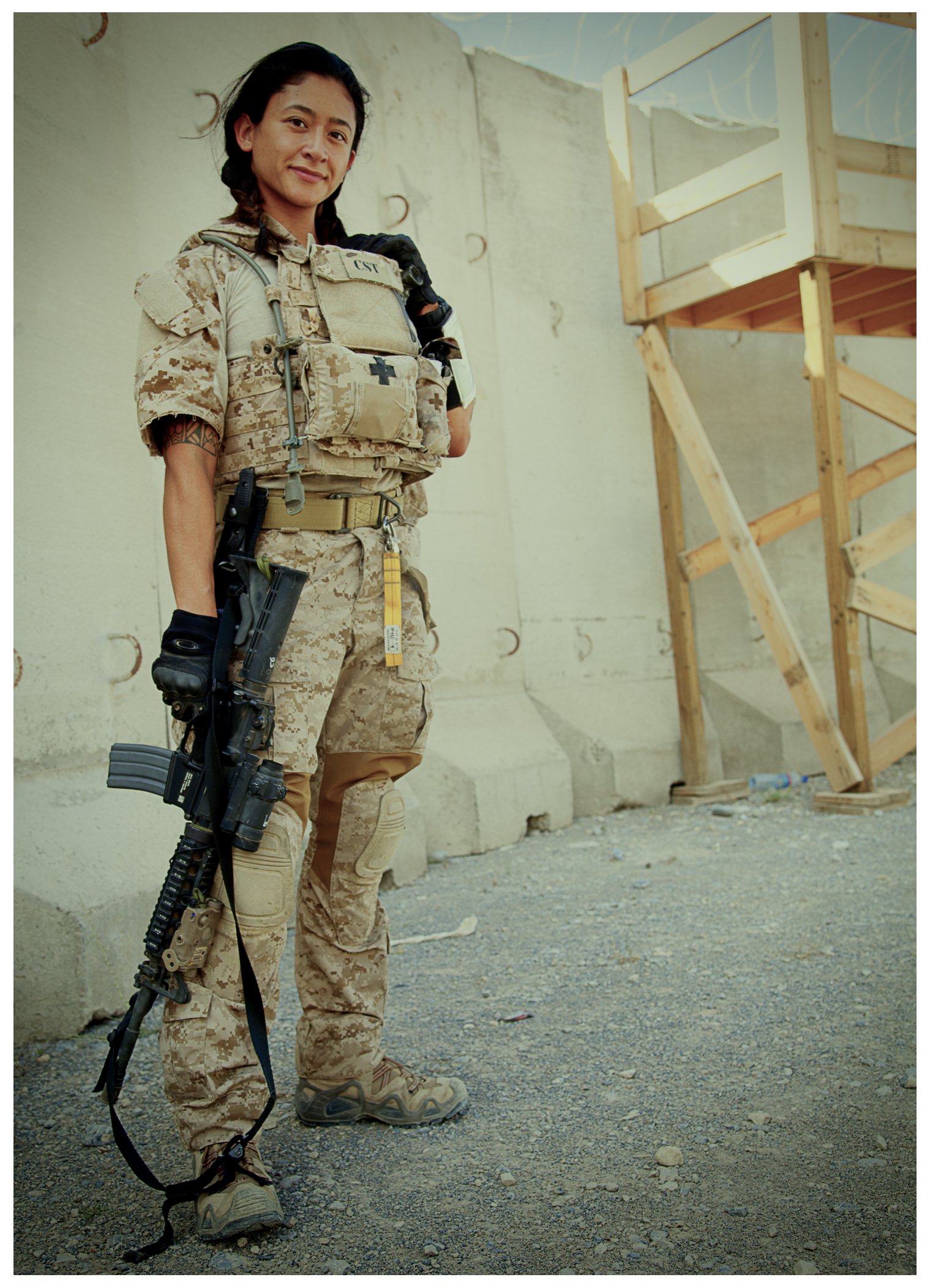 Samantha Juan holding a rifle while stationed outdoors during her military service in Afghanistan.