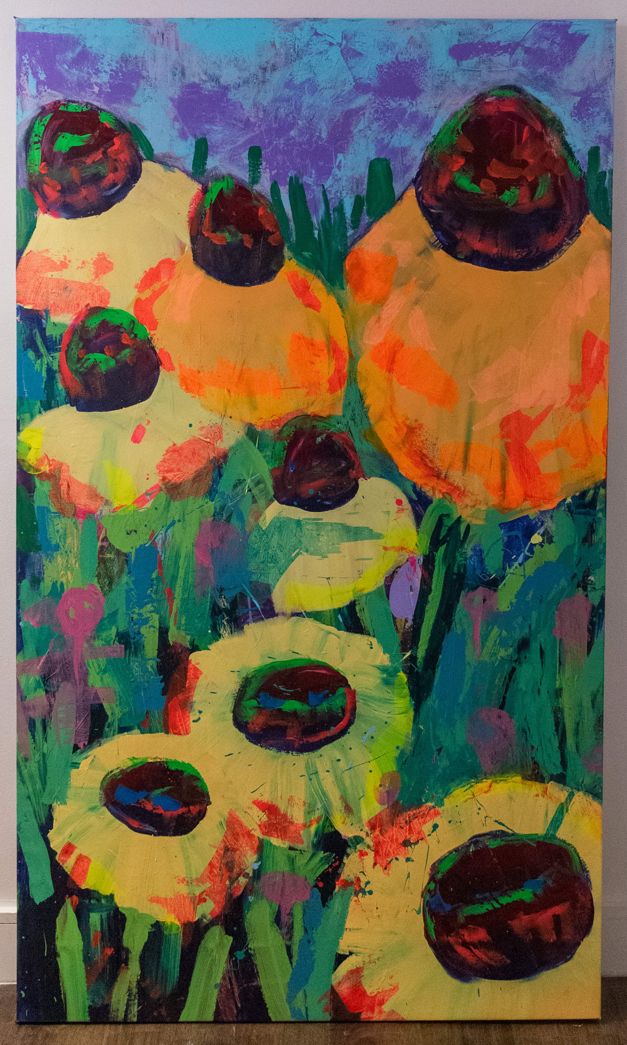 Abstract painting featuring large, dark, circular shapes with vibrant red, green, and blue accents on yellow, purple, and multicolored backgrounds.