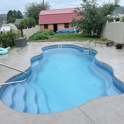 Residential swimming pool prepared for seasonal closing with winter safety cover installed.