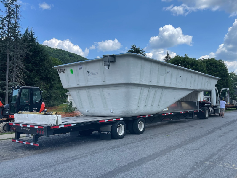 Fiberglass swimming pool being delivered for installation at a residential property in Central Pennsylvania.