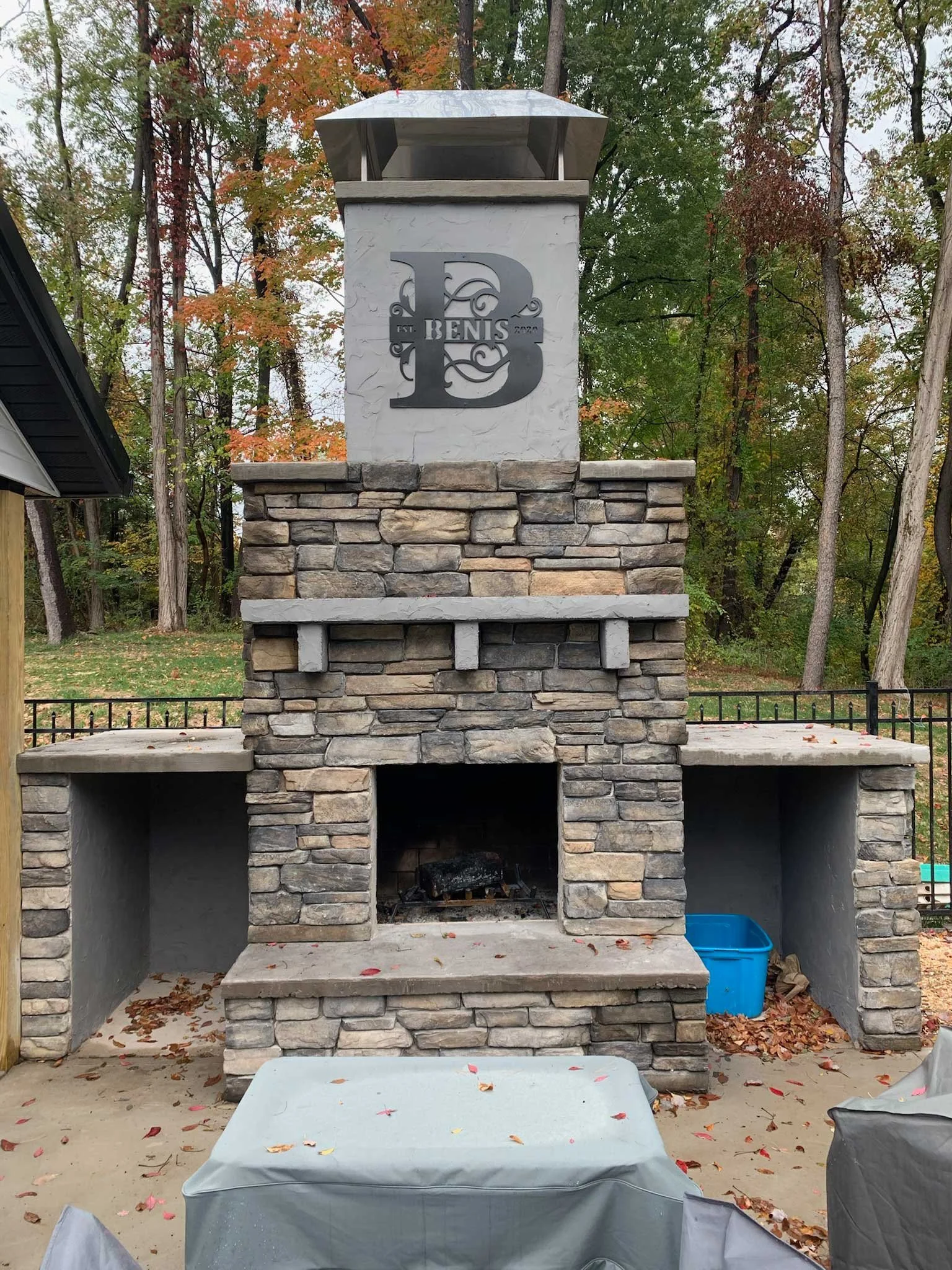 Backyard stone fireplace and outdoor living feature constructed with custom masonry and hardscaping