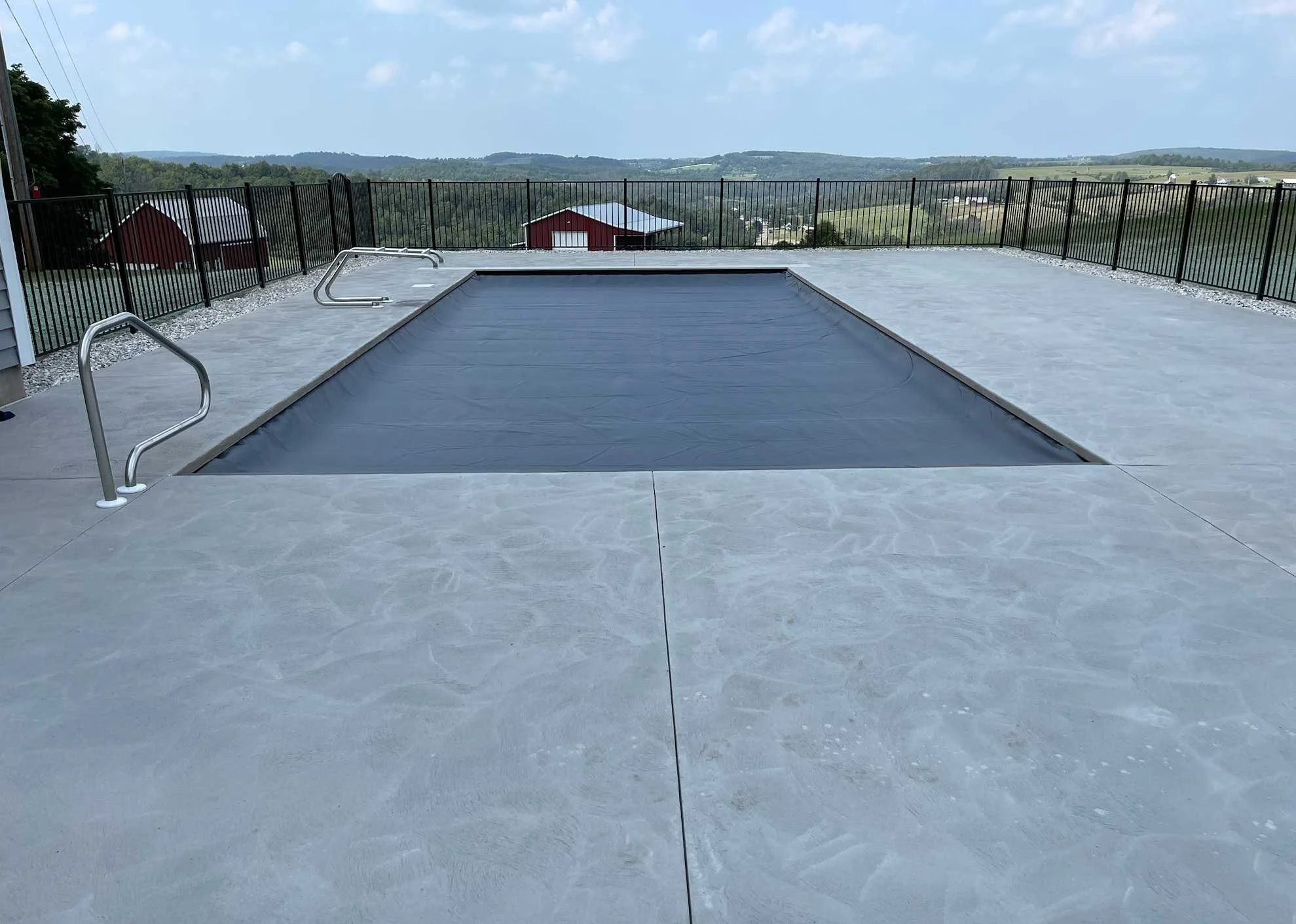 Covered rectangular swimming pool with safety cover and panoramic countryside views