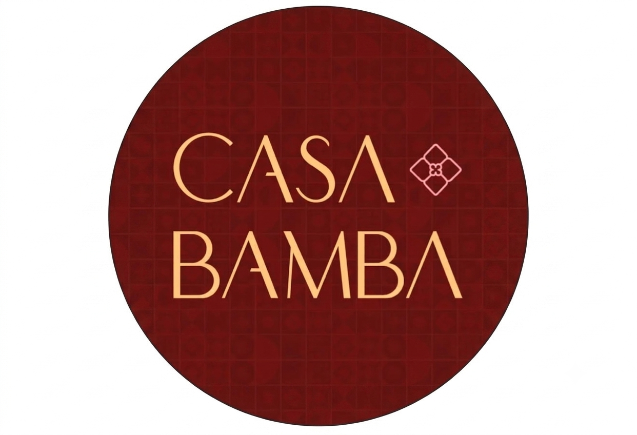 Logo circular de Casa Bamba con fondo rojo oscuro y texto en color beige que dice 'Casa Bamba'.