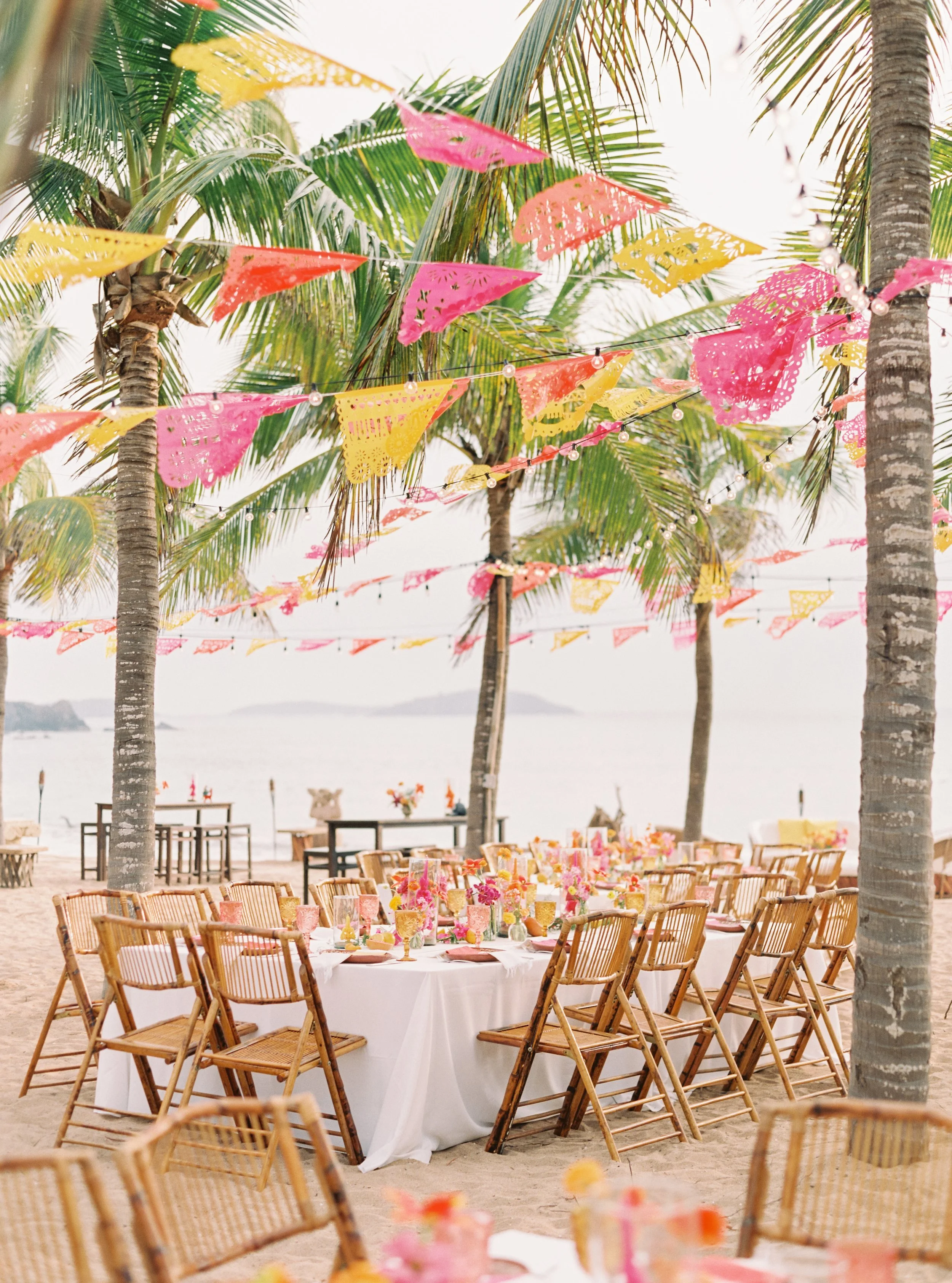 Destination wedding dinner on a beach in Mexico, featuring colorful, Mexican and tropical decor.