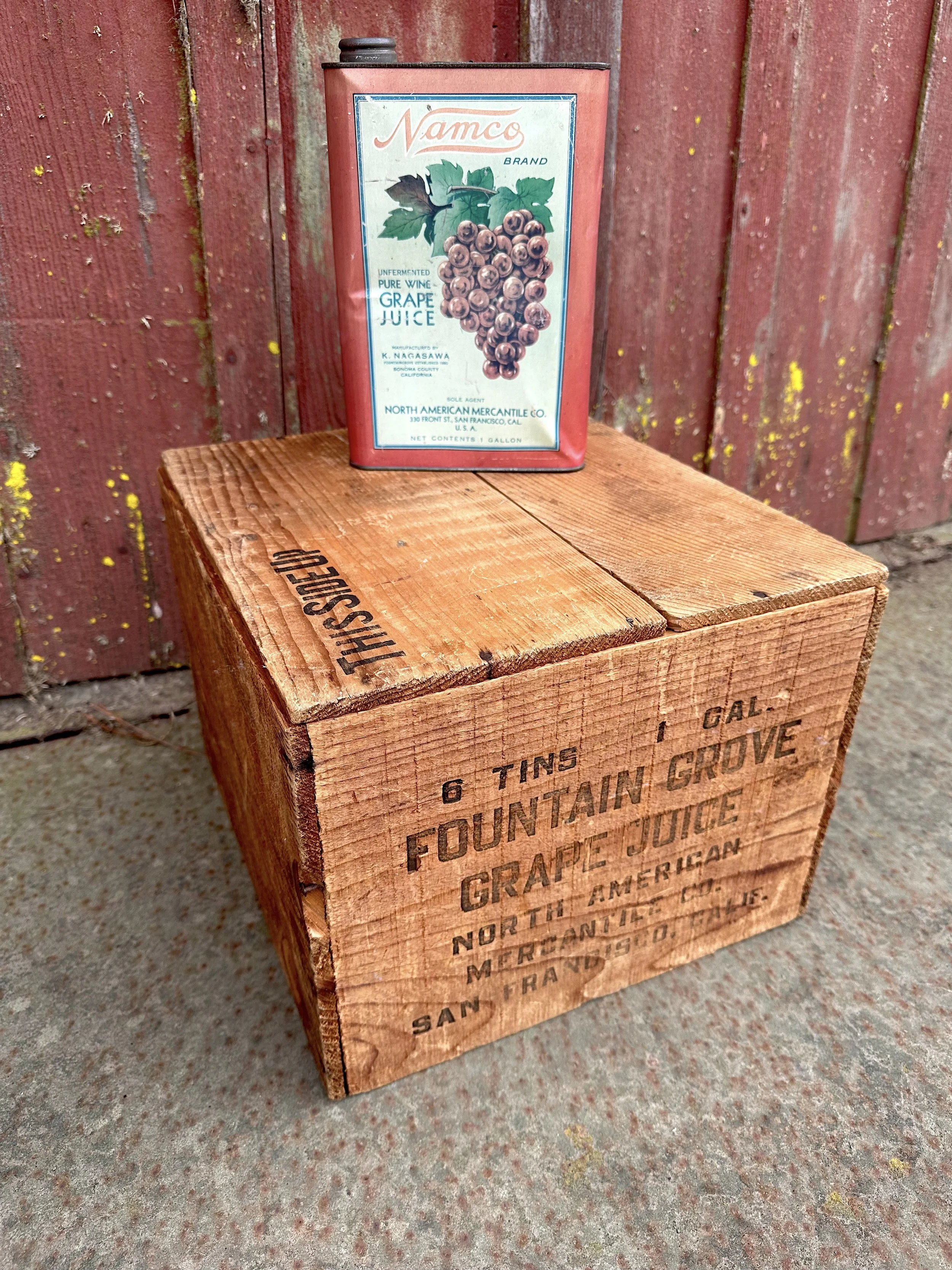An old grape juice can sitting atop a wooden crate.