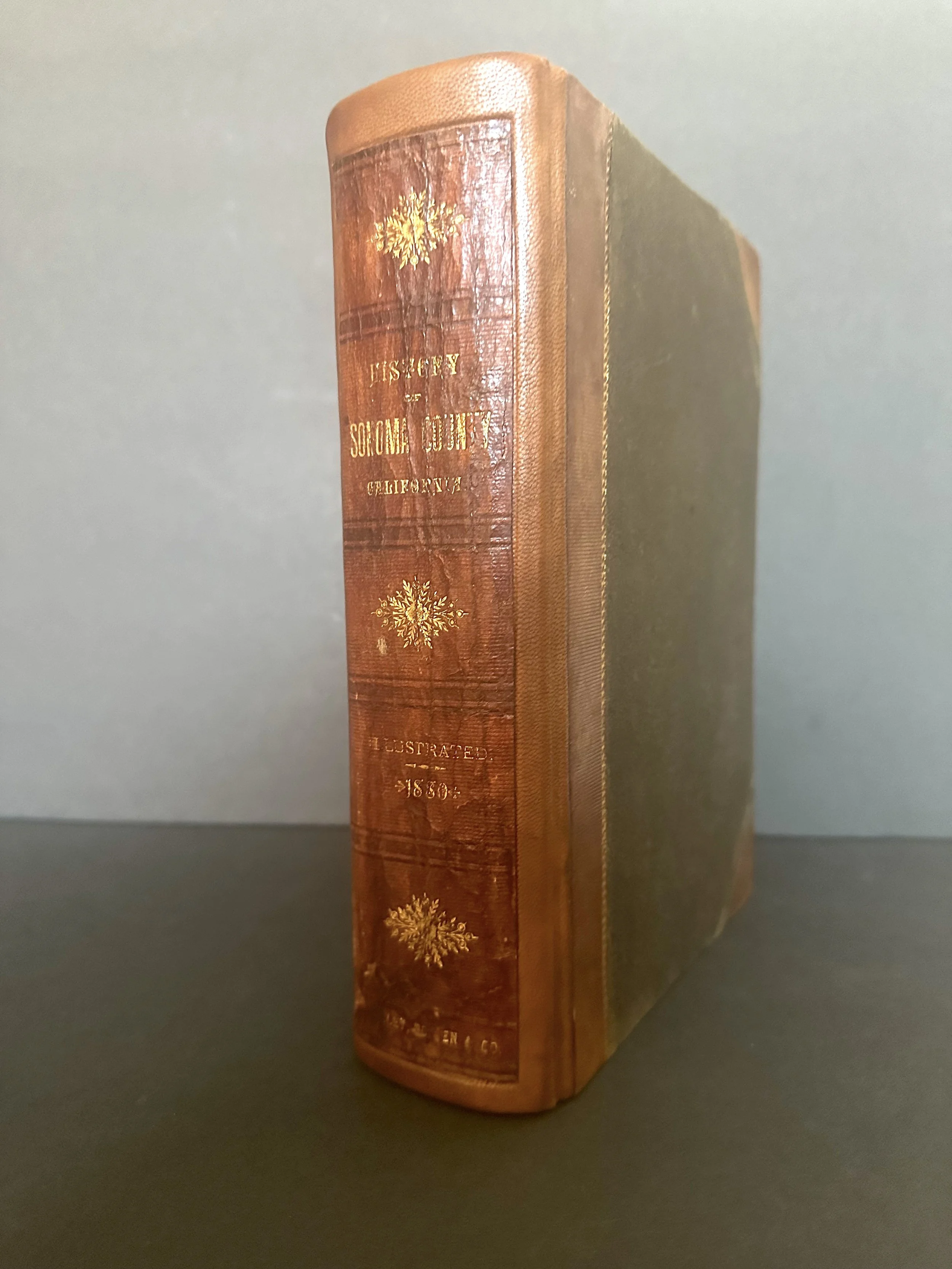 A red, leather bound book with gold lettering.