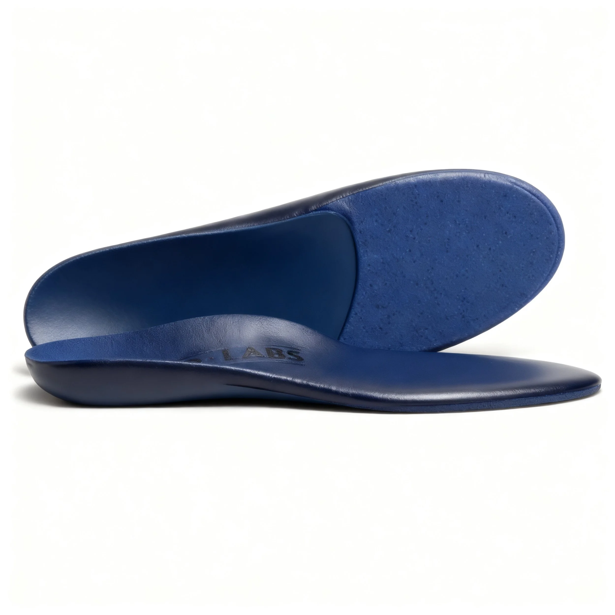 Close-up of blue leather dress shoes stacked on top of each other on a white surface.