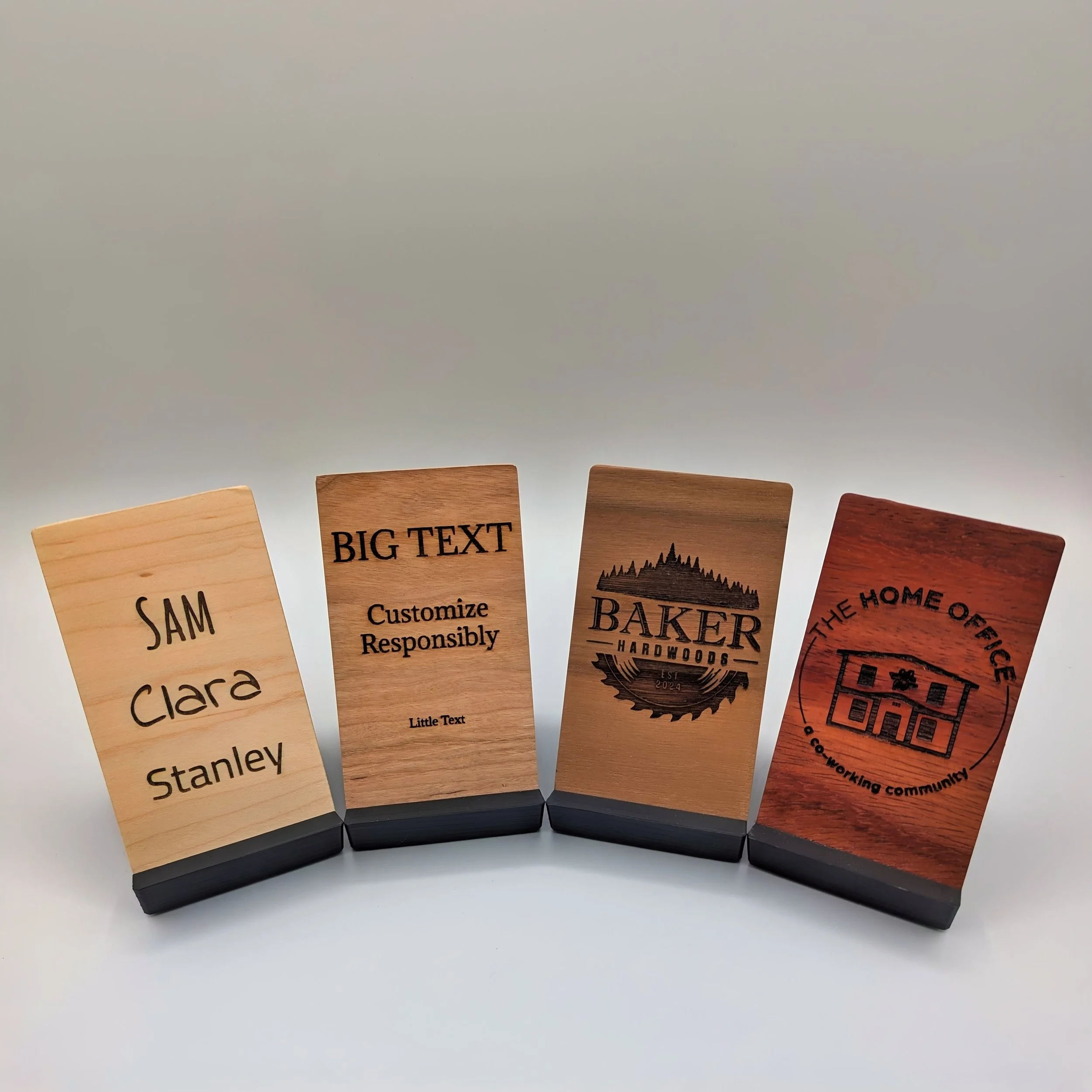 A row of wooden board samples with various texts and designs, each with a black base.