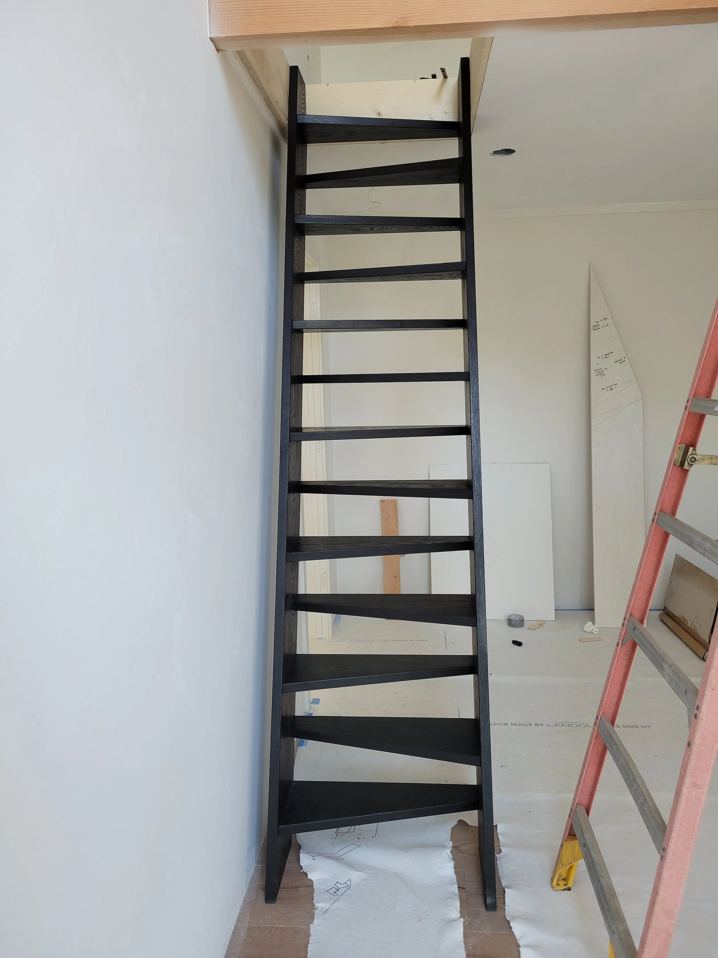 Custom milled white oak loft ladder stained black and installed