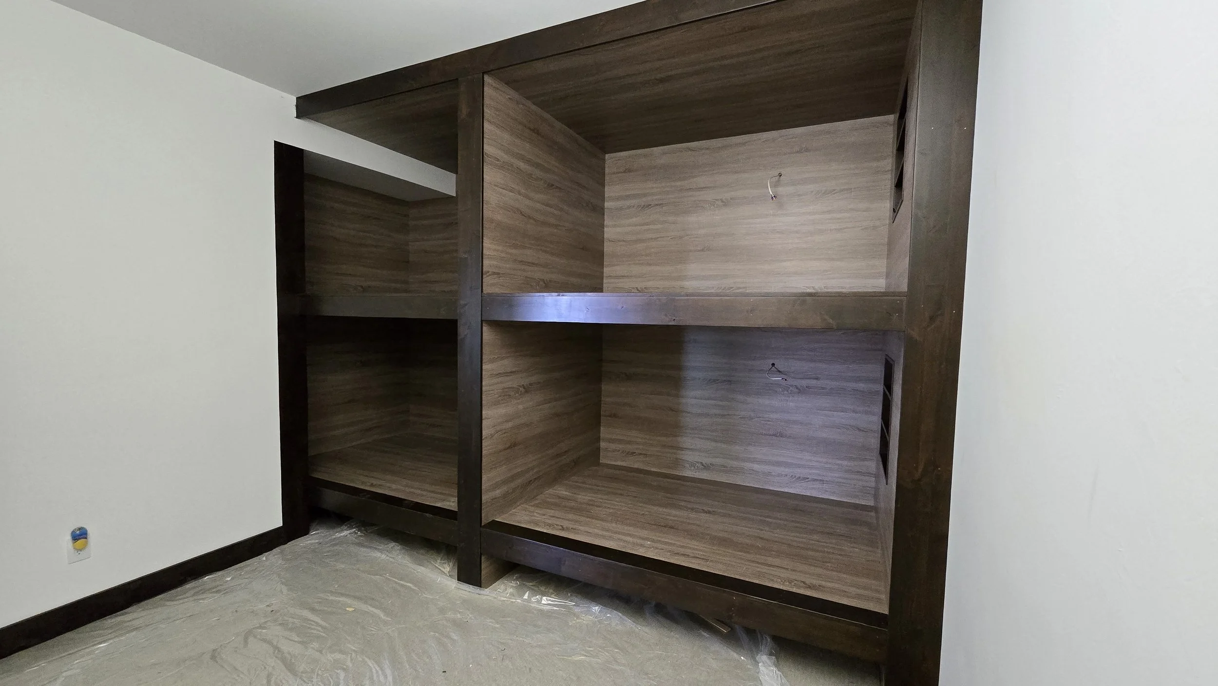 Custom design built-in bunkbeds for four full XL matresses each bed with its own light, shelving and outlet