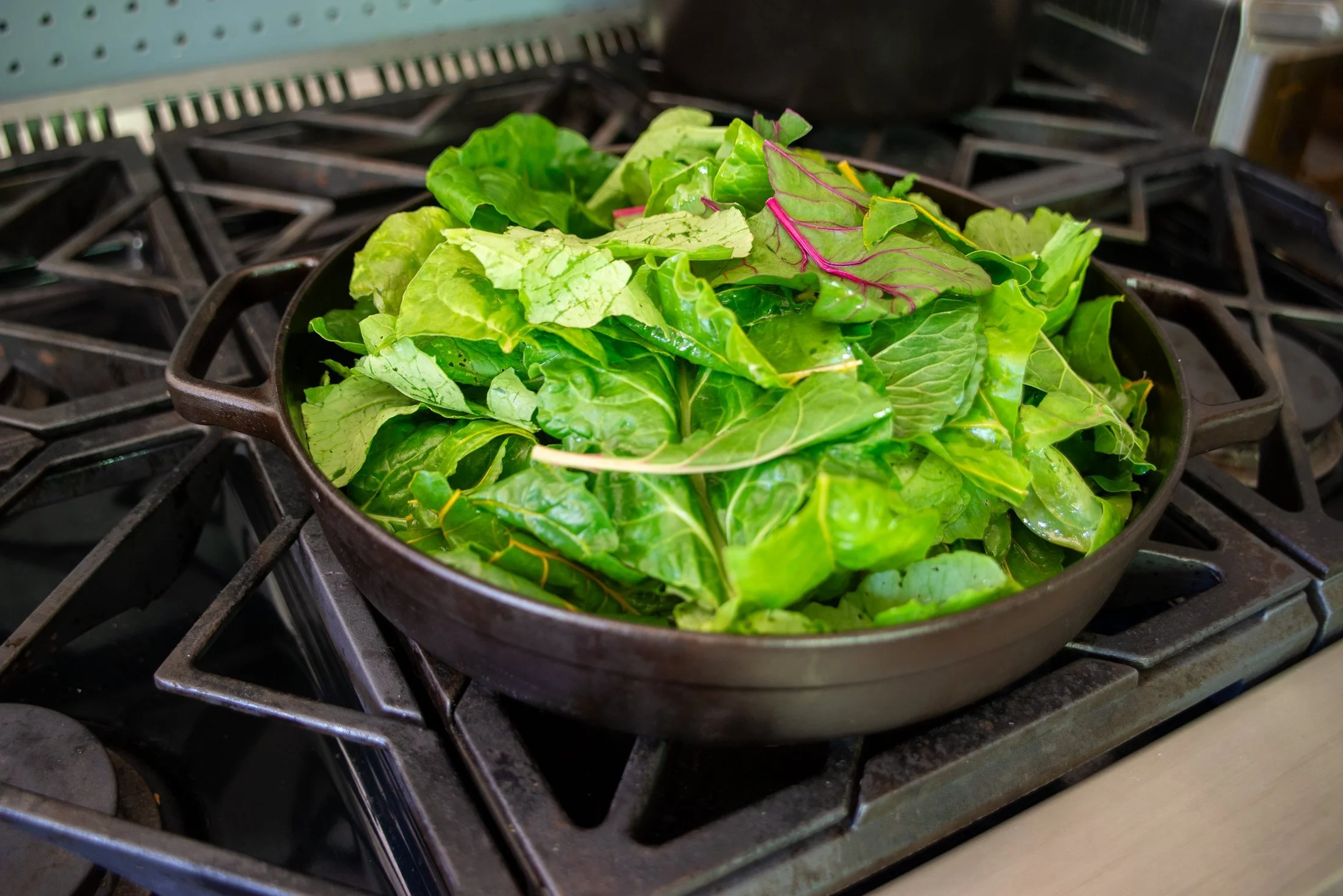 Rainbow chard cooking in a cast iron skillet  by Borough Furnace