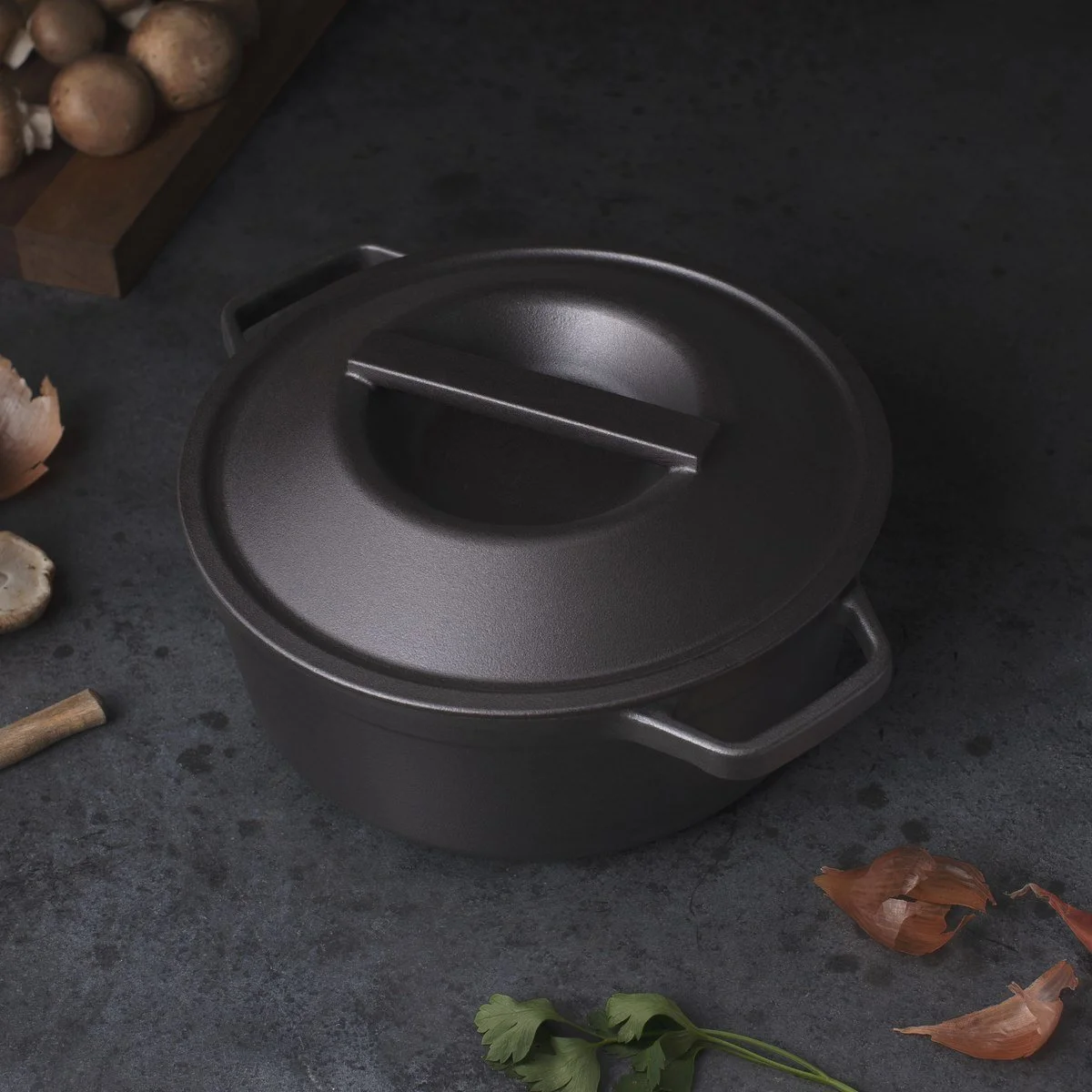 Borough Furnace seasoned cast iron dutch oven in kitchen setting with mushrooms and fresh herbs