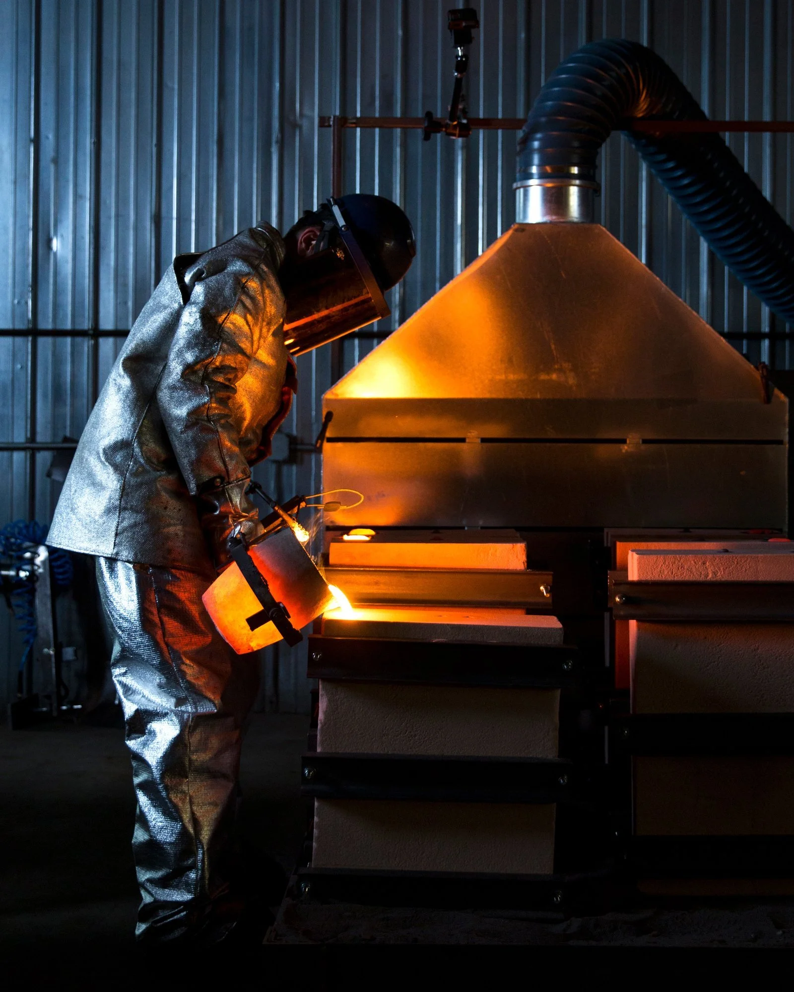 John Truex pouring molten iron into a sand mold to make a Borough Furnace skillet