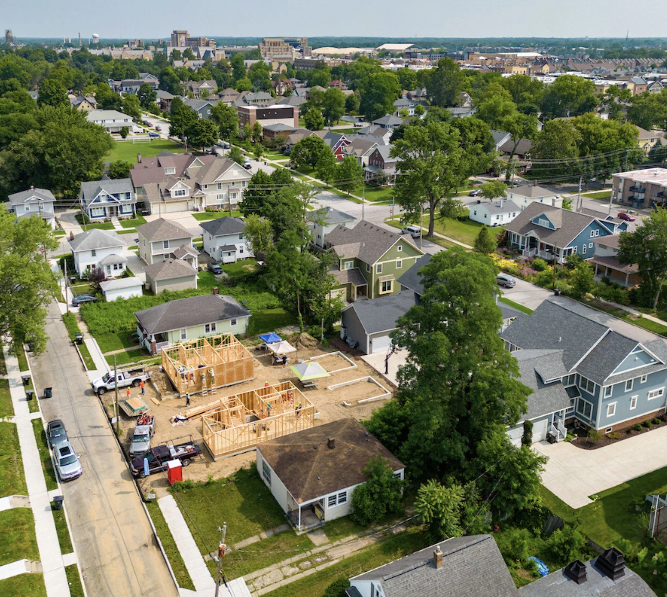 Aerial view of a suburban neighborhood with houses, trees, and streets, with some ongoing construction of new homes.