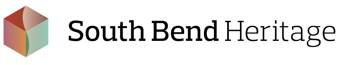 South Bend Heritage Logo that has black text and a hexagon with three shades of red and a shade of grey.