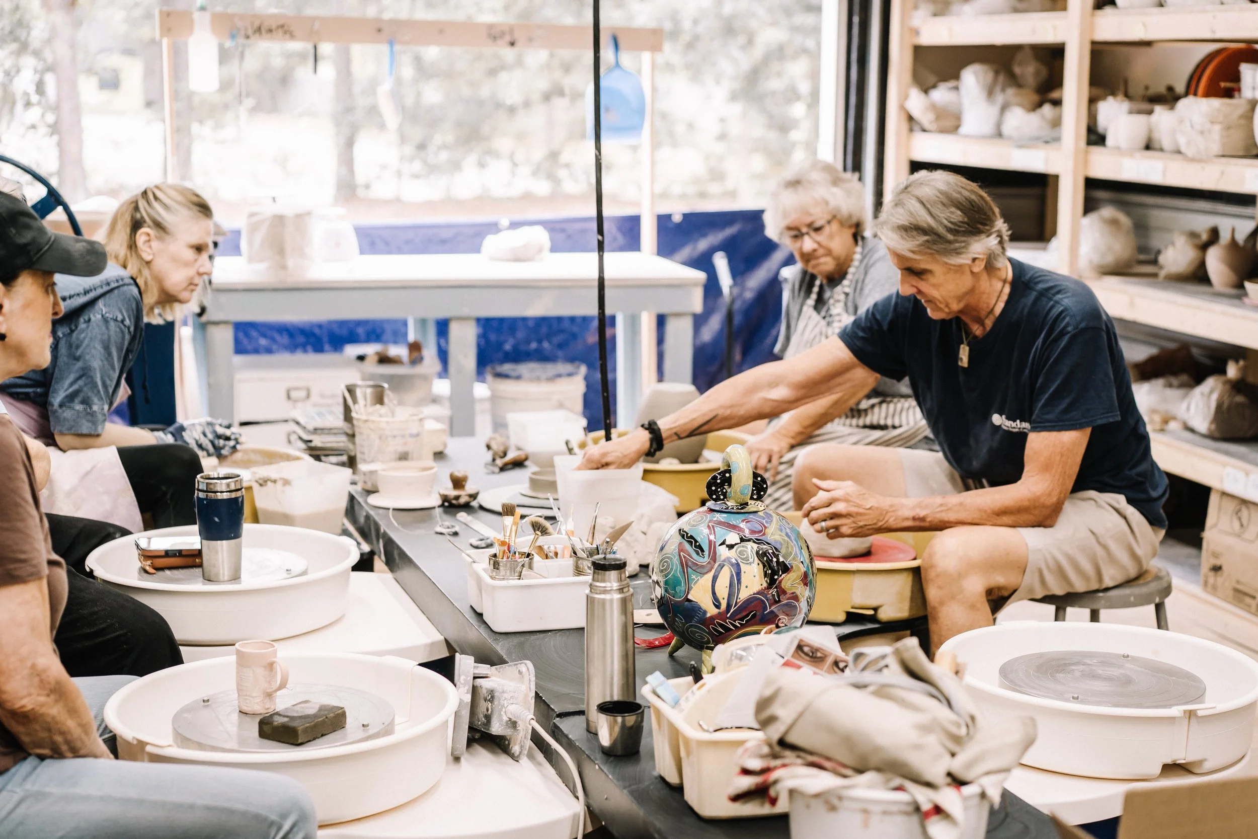 Adult students throwing handmade ceramic bowls on pottery wheels in Richmond Virginia