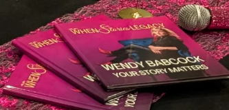 Stack of pink books titled 'When Women Lead' by Wendy Babcock with a microphone nearby.