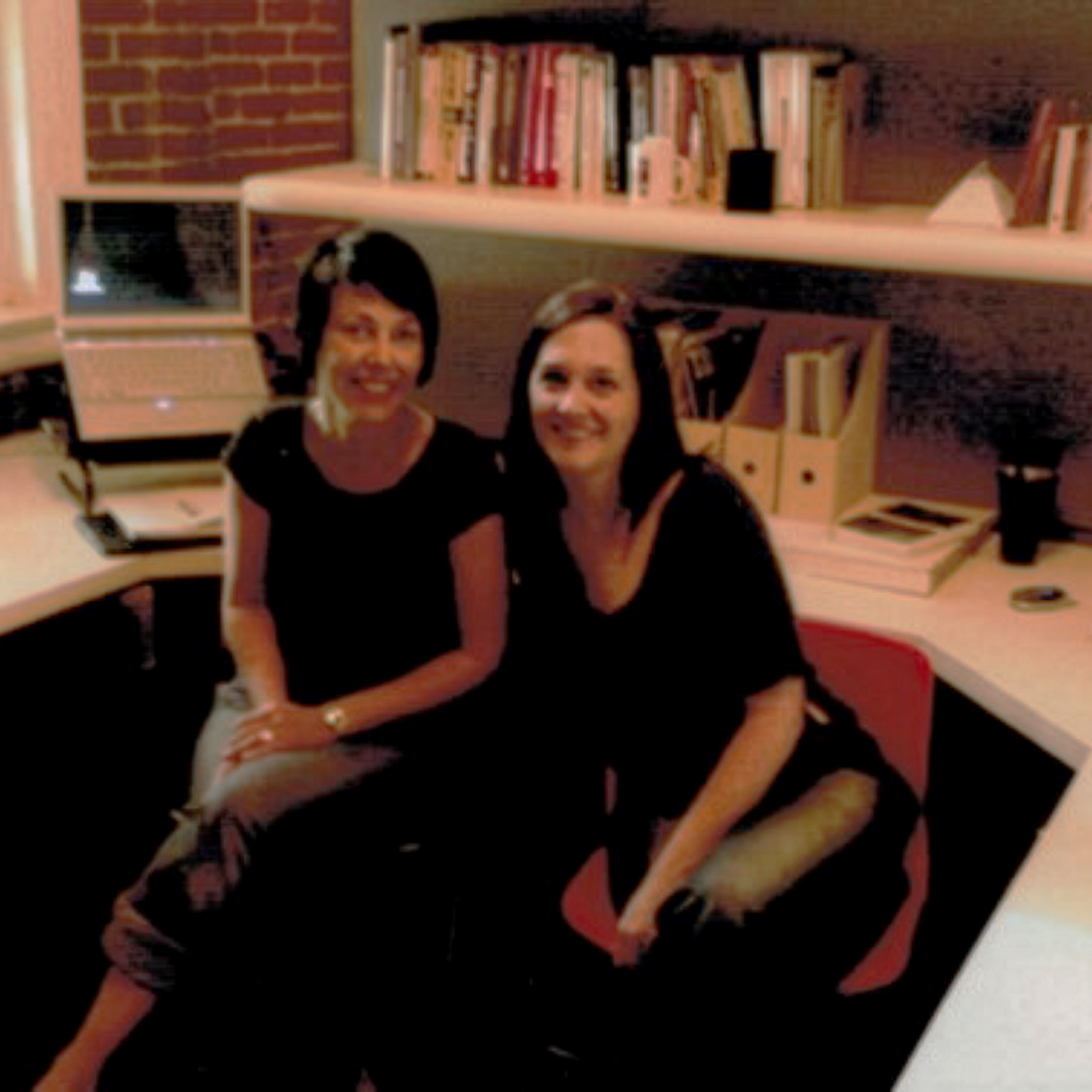 Jillian Douglas and Shannon McKenzie, co-founders of Idea Learning, sitting in an office and smiling at the camera with bookshelves and office supplies in the background.