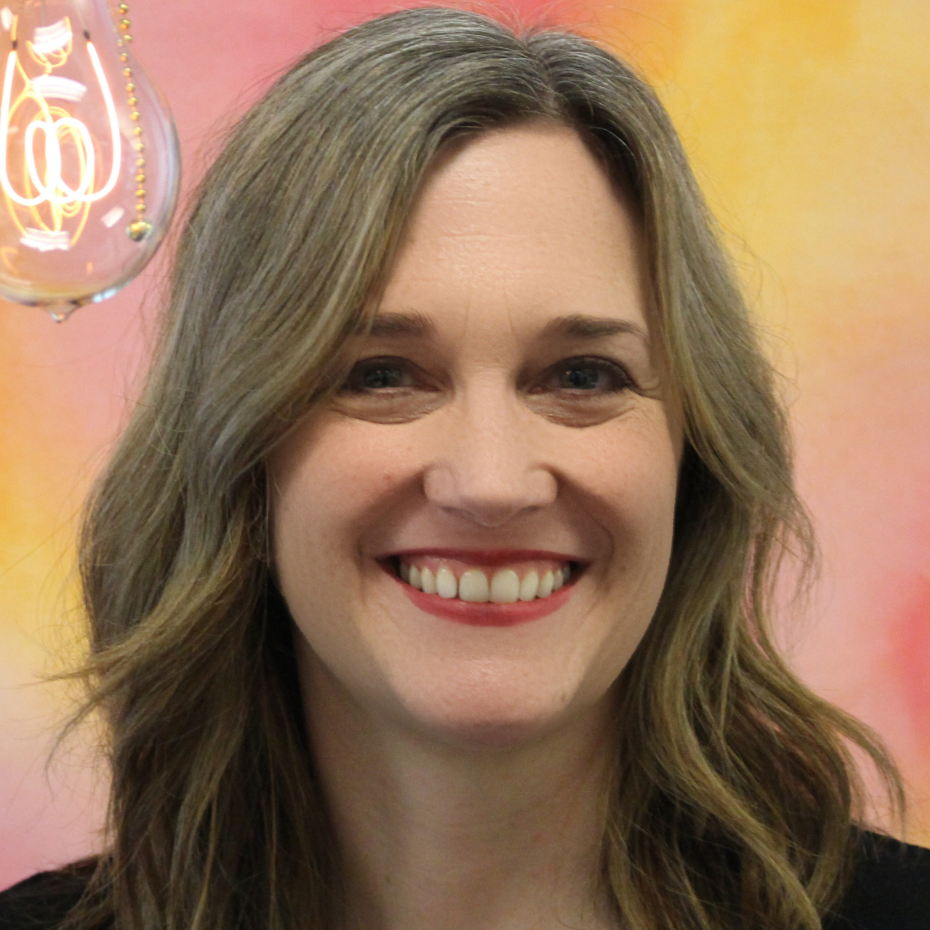 Shannon McKenzie smiling with wavy, light brown hair, standing in front of a colorful background.