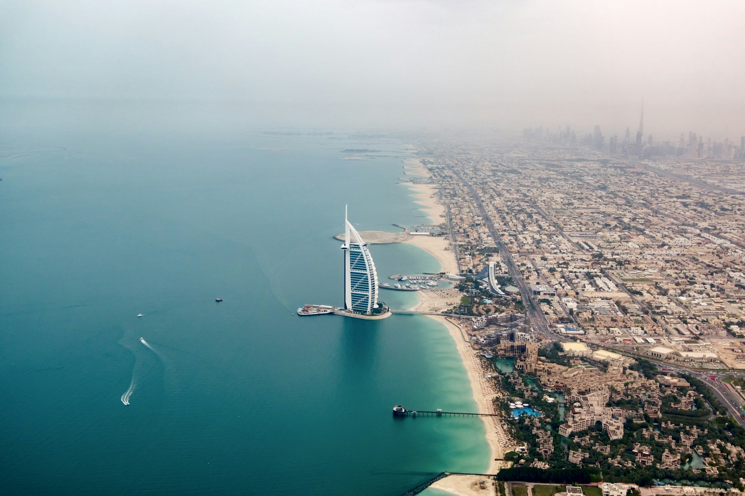 Aerial view of Dubai Marina with the Burj Al Arab hotel and Dubai city skyline.