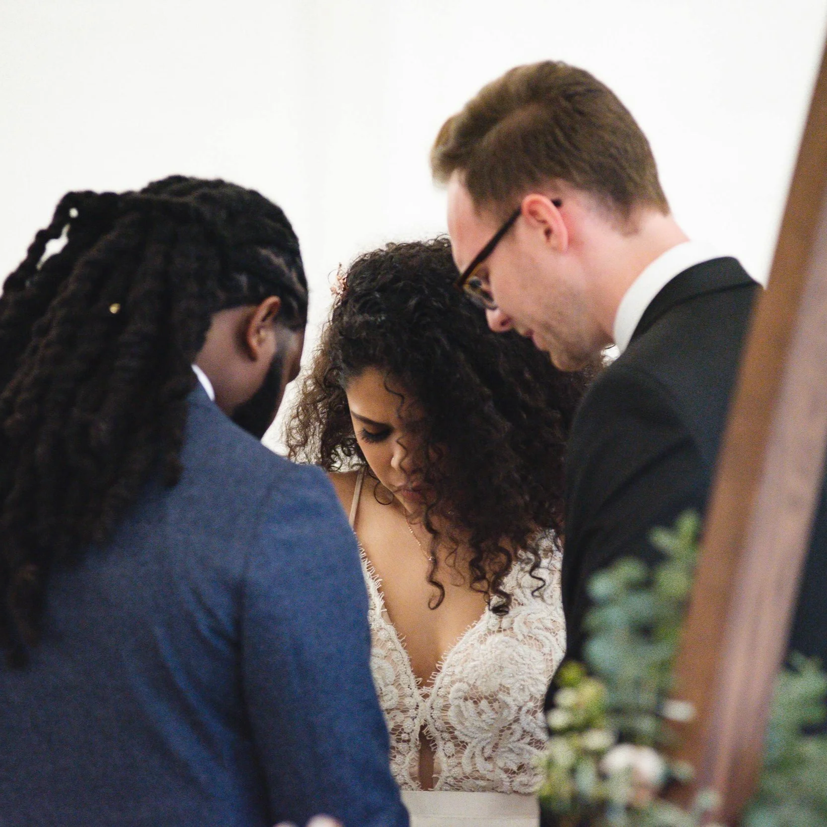 Wedding Officiant prays with bride and groom.