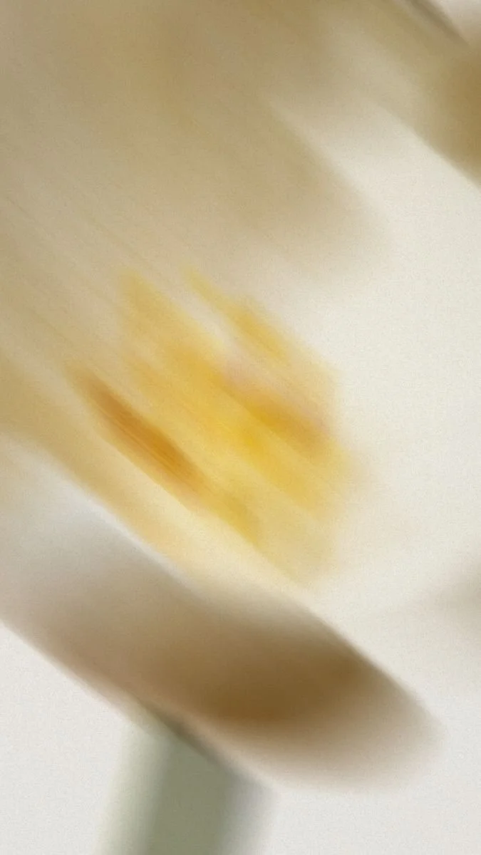 Blurry image of a yellow object, possibly popcorn, on a light-colored surface.