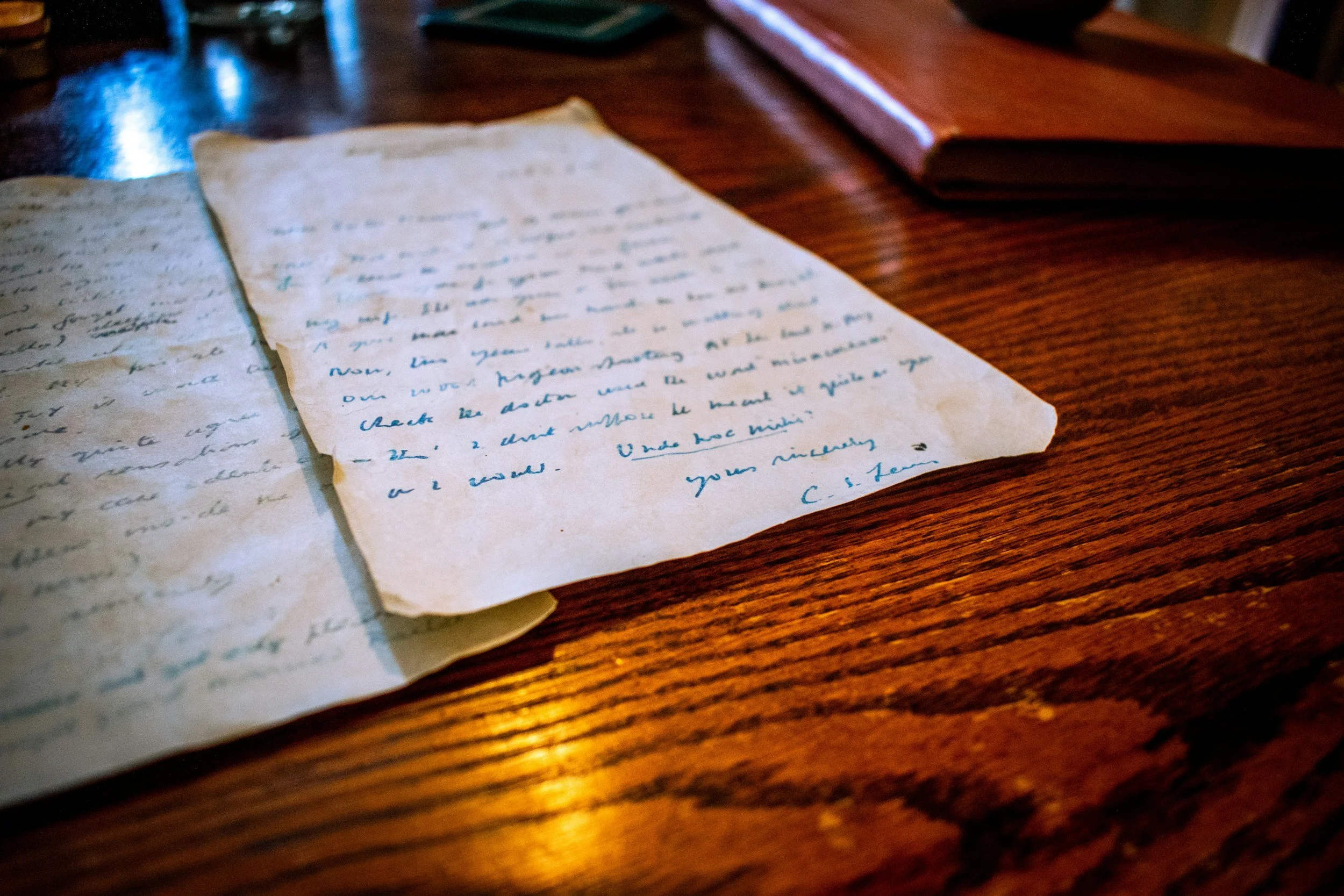Old handwritten letters from C.S. Lewis on a wooden table.
