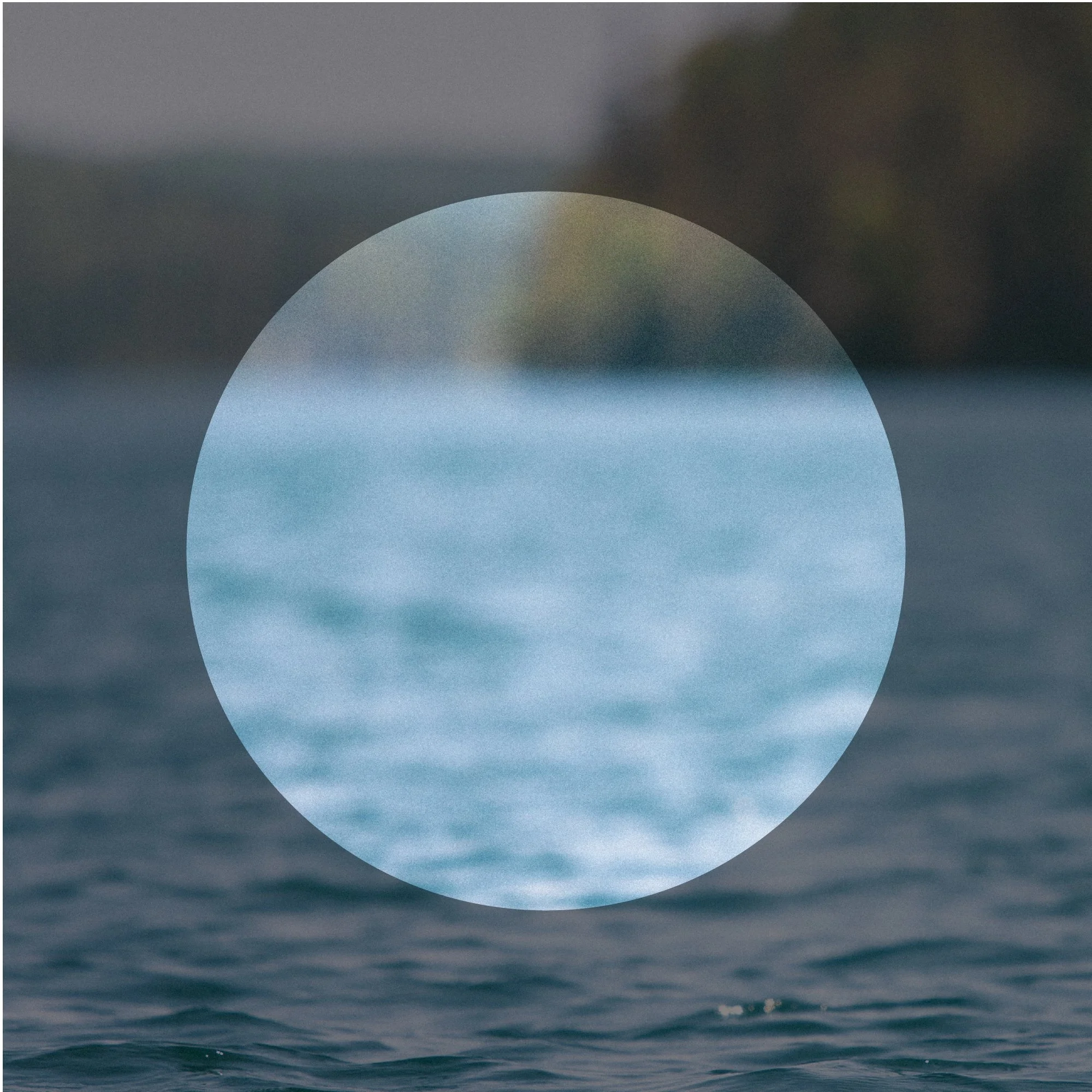A large white spherical object partially submerged in a body of water with dark clouds or sky in the background.