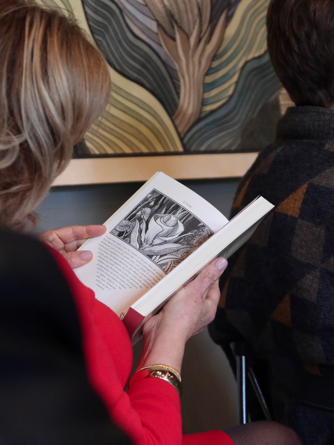 Un momento del racconto digitale e della narrazione live durante il finissage della mostra Incibus a Mantova. Interazione del pubblico con i cataloghi d'arte.