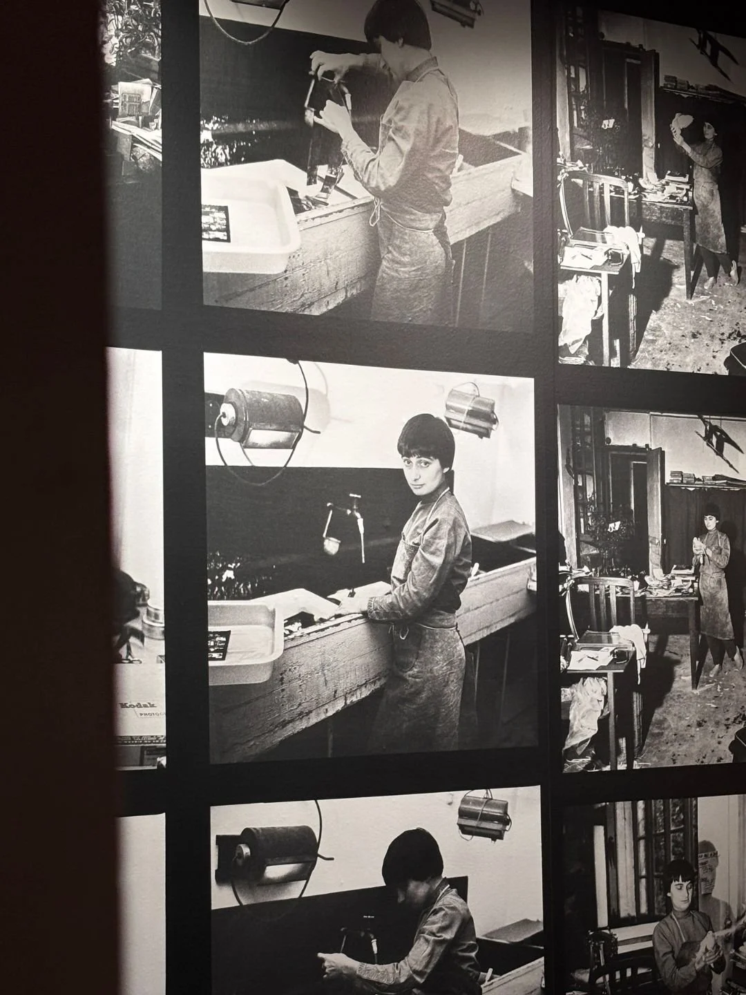 Una sequenza di fotografie in bianco e nero di una donna con capelli corti e sbarazzina che lavora in uno studio fotografico, con apparecchiature e libri sul tavolo.